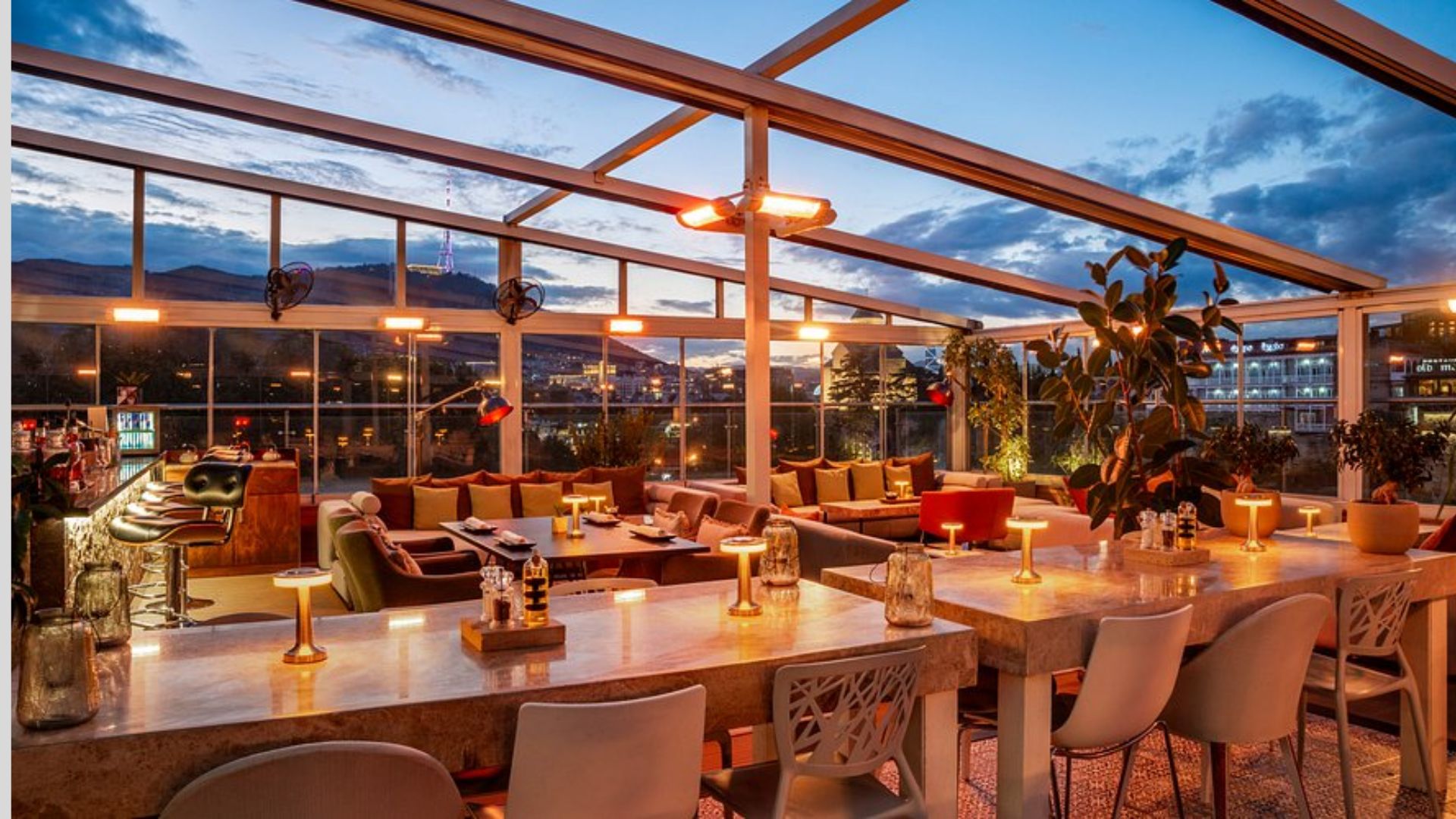 The hotel bar illuminated at night, showcasing a vibrant atmosphere with glowing lights and stylish decor.