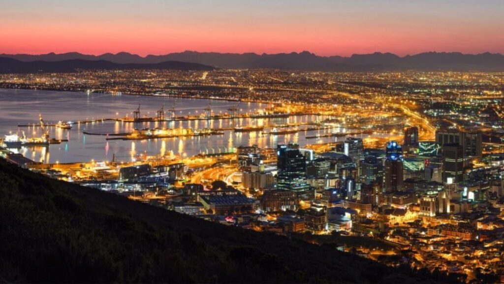 Cape Town skyline at dusk, with vibrant colors illuminating the city and Table Mountain in the background.