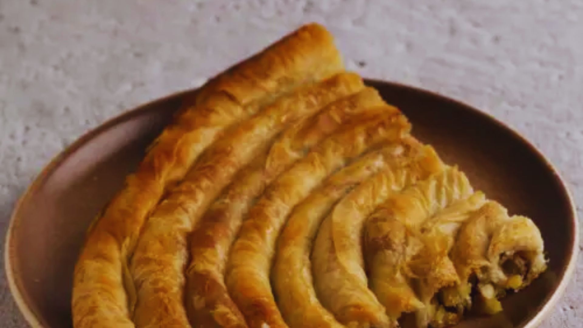 A slice of pie on a white plate, accompanied by a silver fork resting beside it.