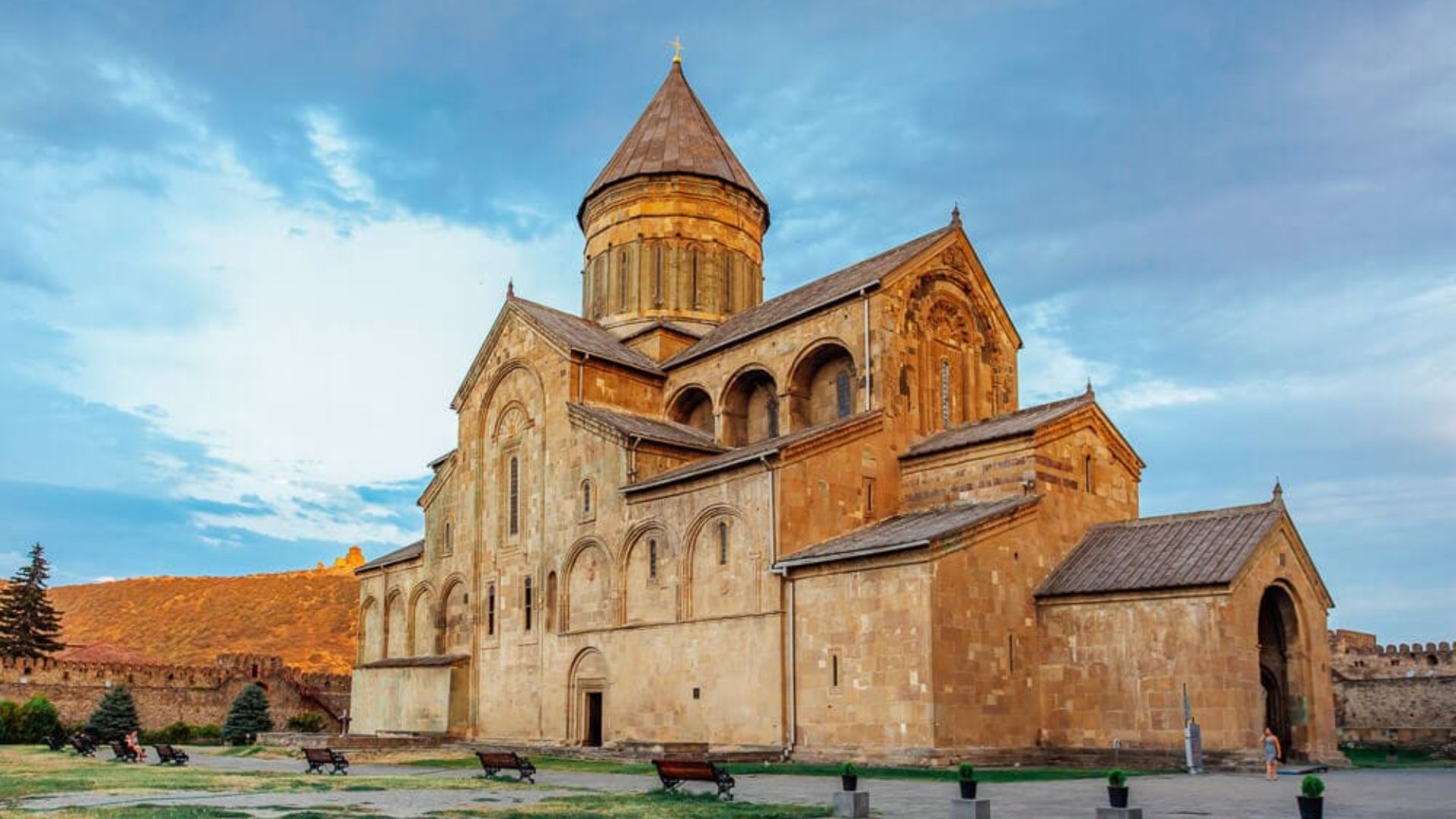 The Church of the Holy Cross in Armenia, featuring ancient stonework and a picturesque landscape.