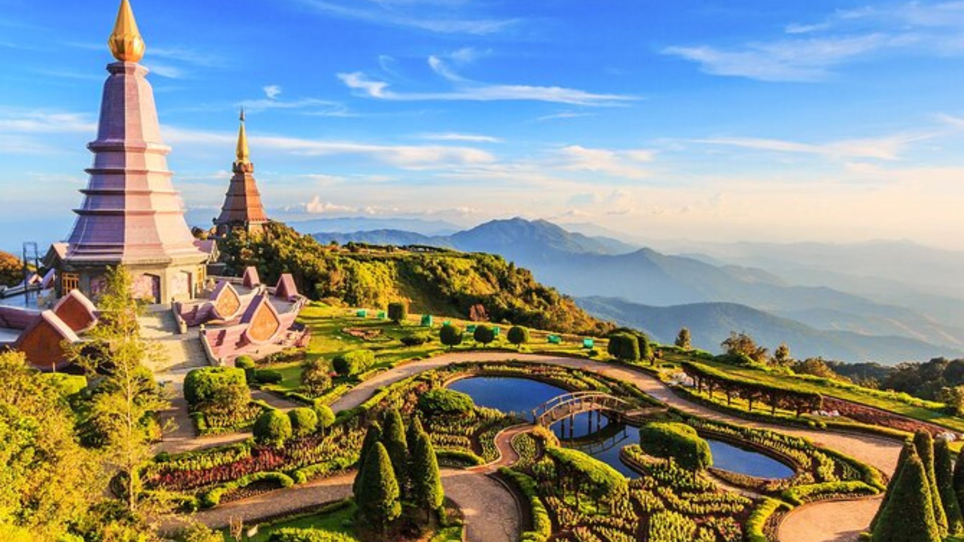 Scenic view of Wat Phra That in Thailand, showcasing lush greenery and traditional architecture against a clear blue sky.