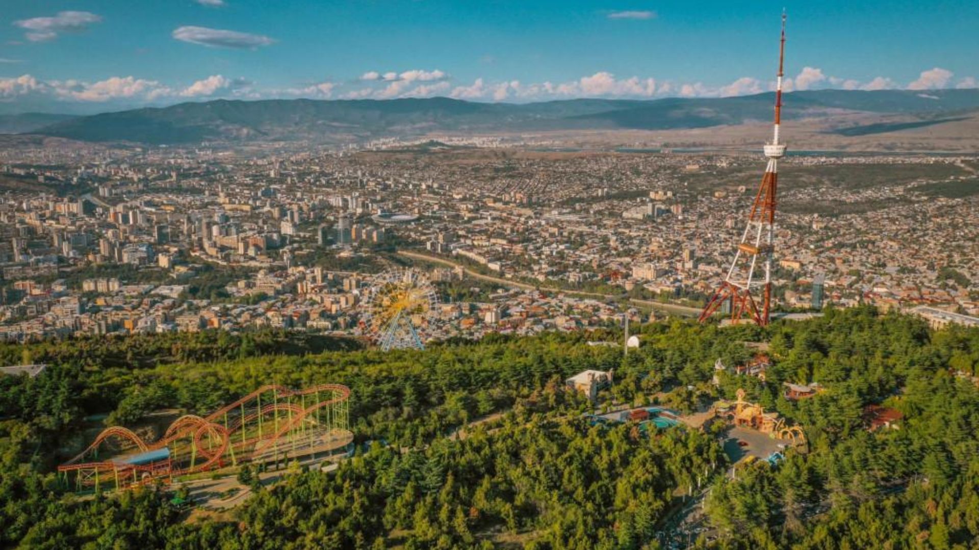 A panoramic view of Yerevan city from a mountain top, showcasing its architecture and surrounding landscape.
