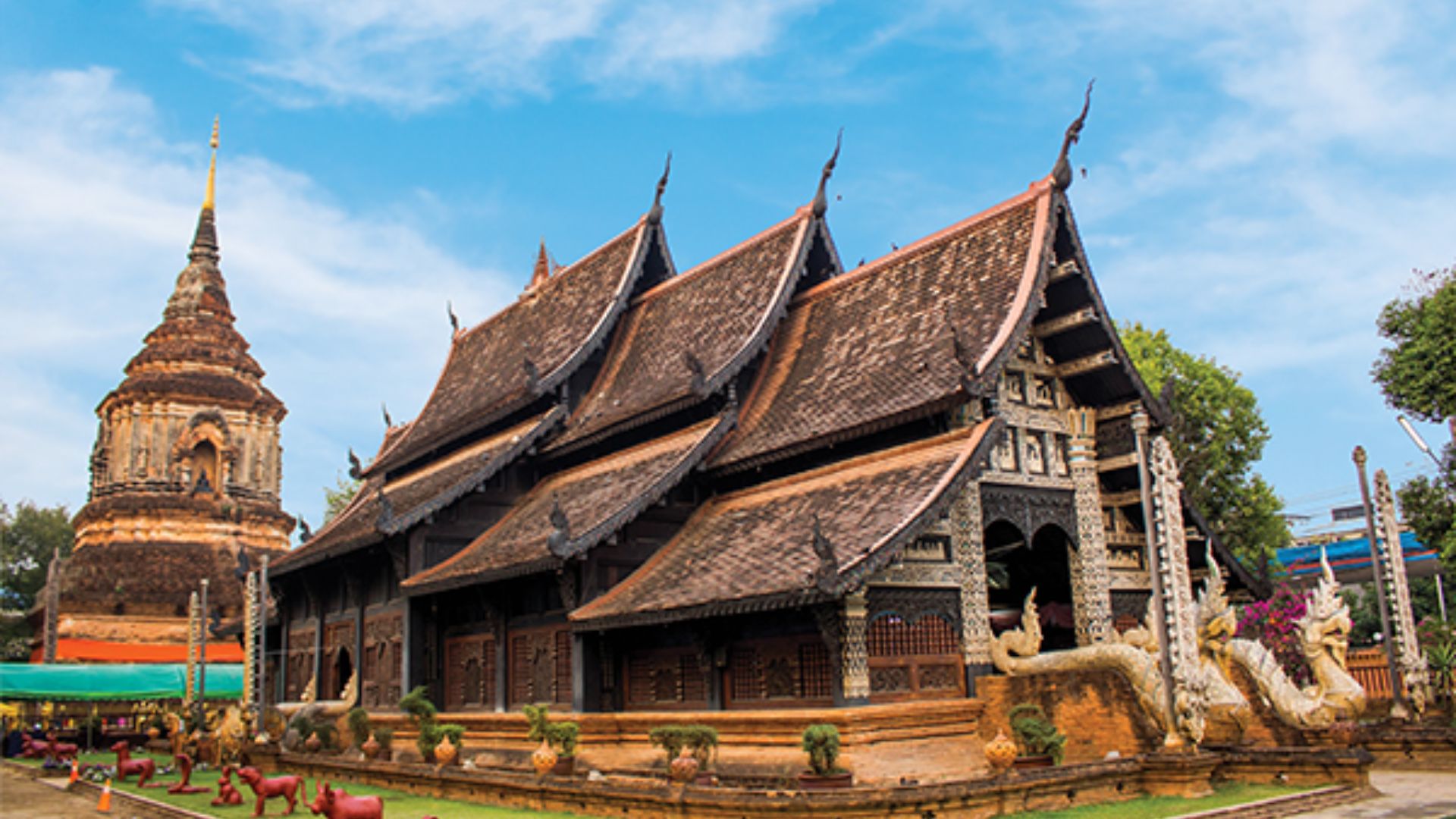 A serene Buddhist temple in Thailand, featuring ornate architecture and lush greenery surrounding the peaceful structure.