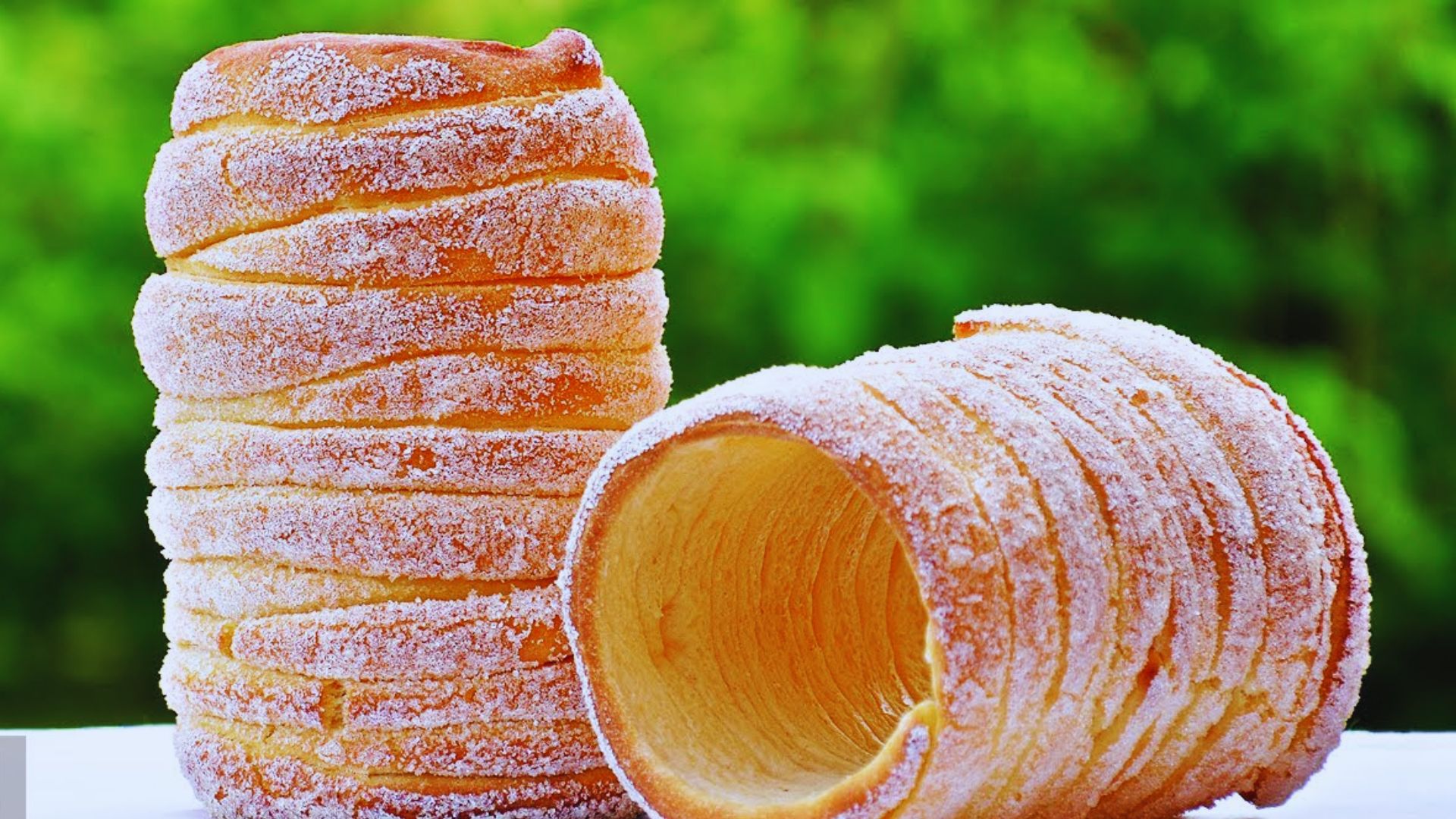 Two pastry doughnuts stacked on top of each other, showcasing their golden-brown glaze and fluffy texture.