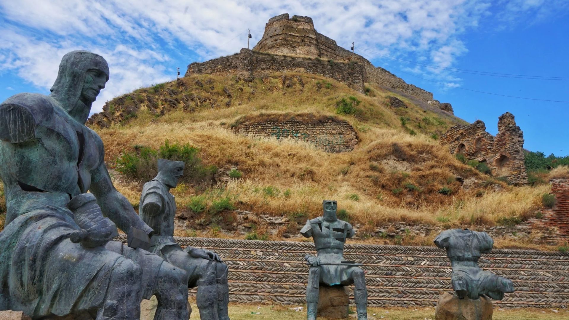 Statues of soldiers stand guard in front of a historic castle, showcasing military honor and architectural grandeur.