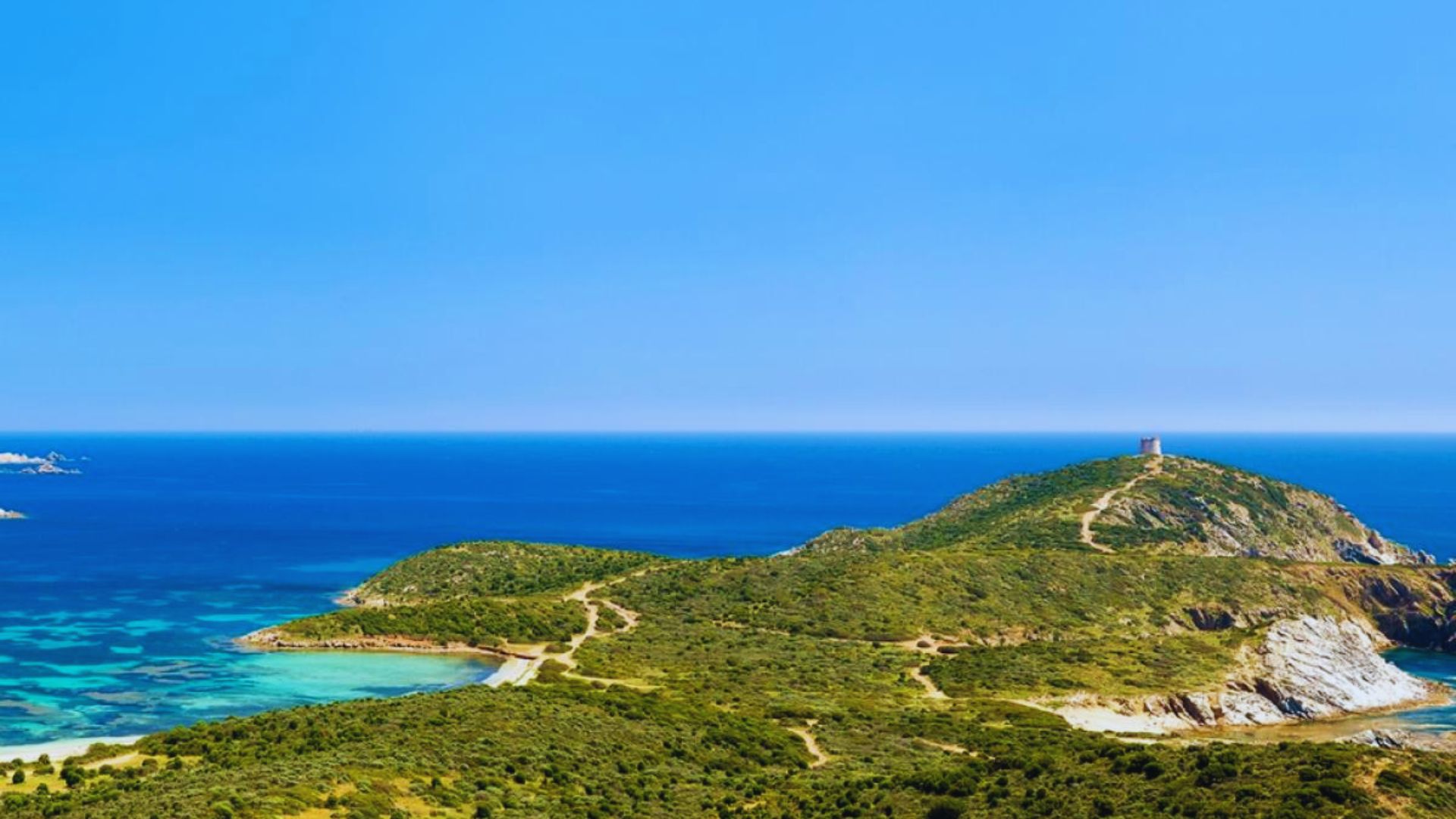 A coastal landscape with vibrant blue sea and sky, green hills, and a winding path leading to a small stone tower on a hilltop, conveying tranquility.