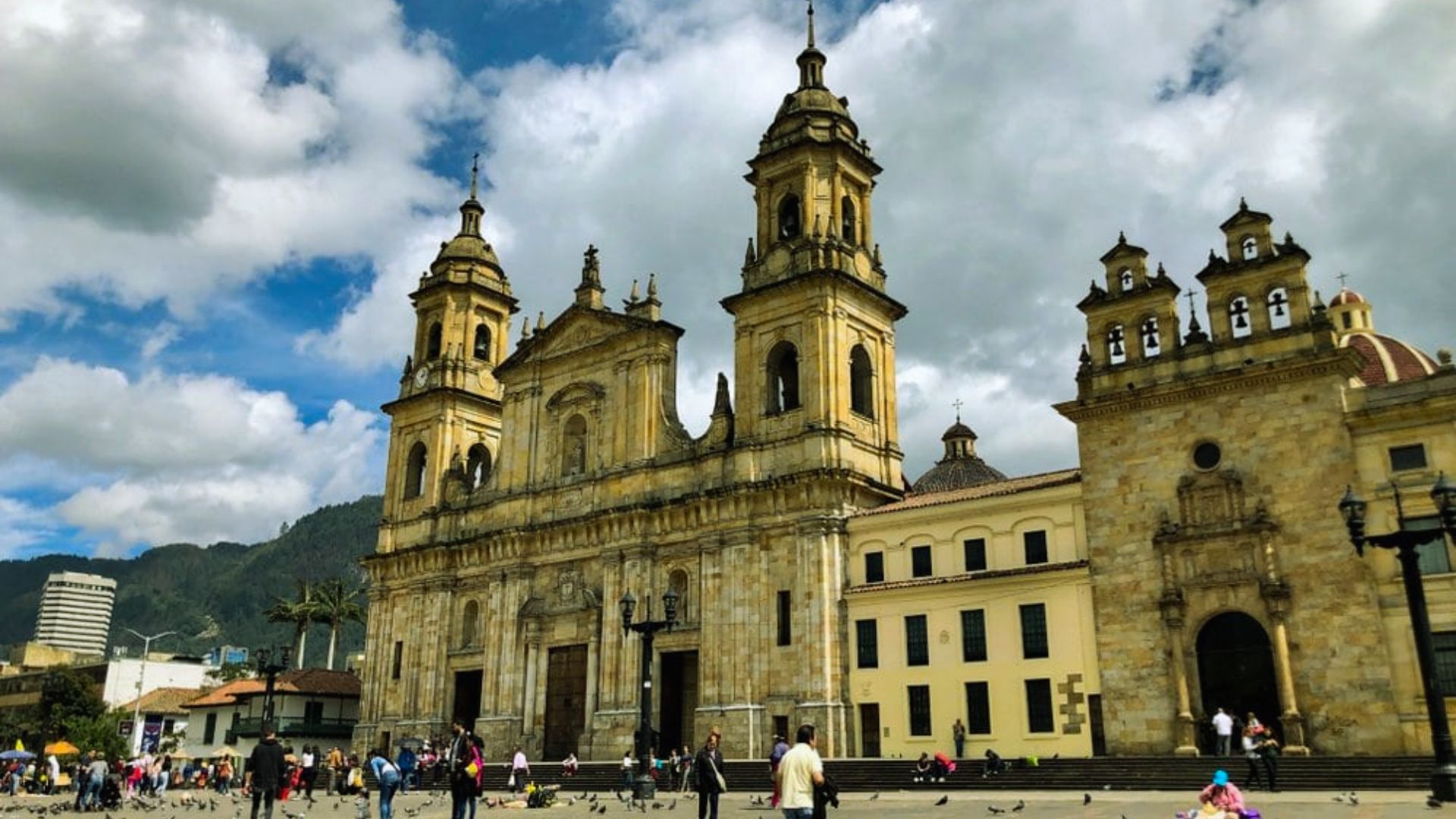 A large cathedral surrounded by numerous people walking and exploring the area.