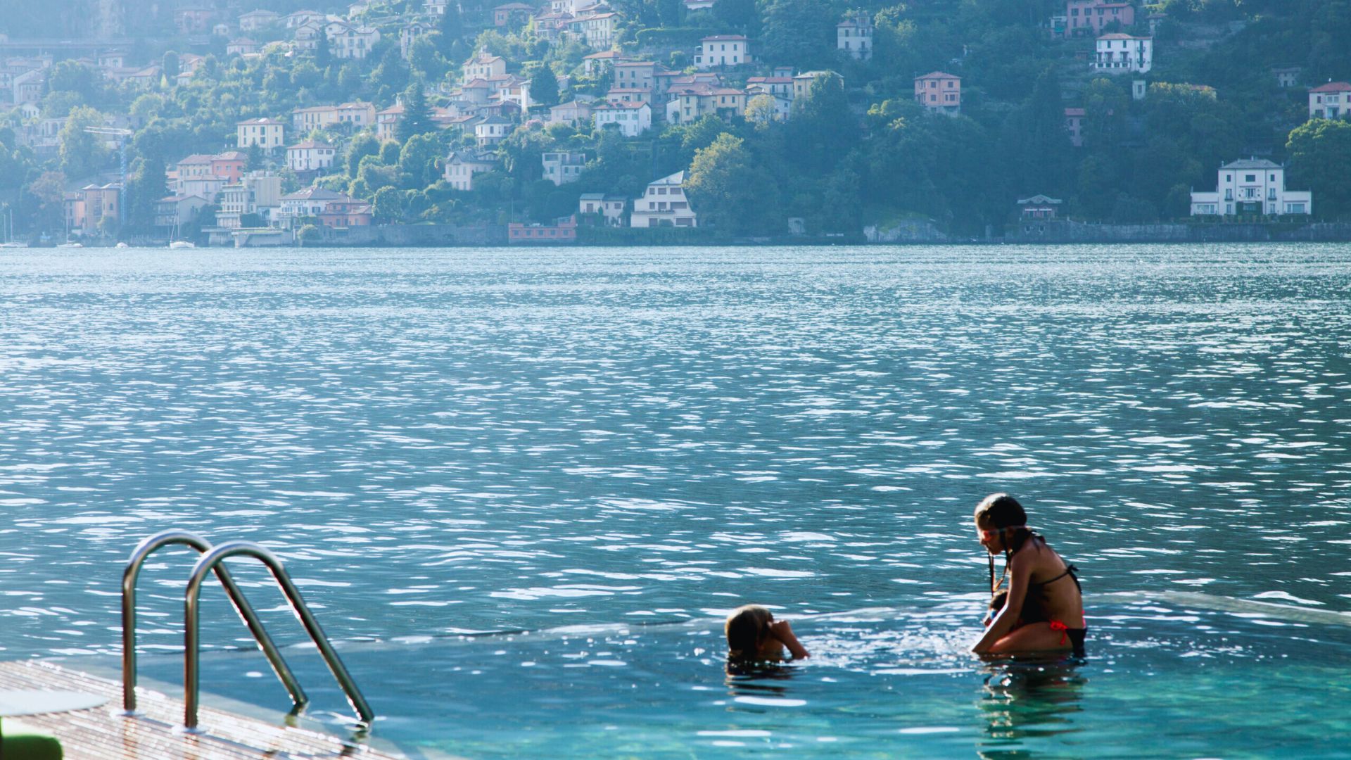 A man and a woman wading in the water, smiling and interacting with each other.
