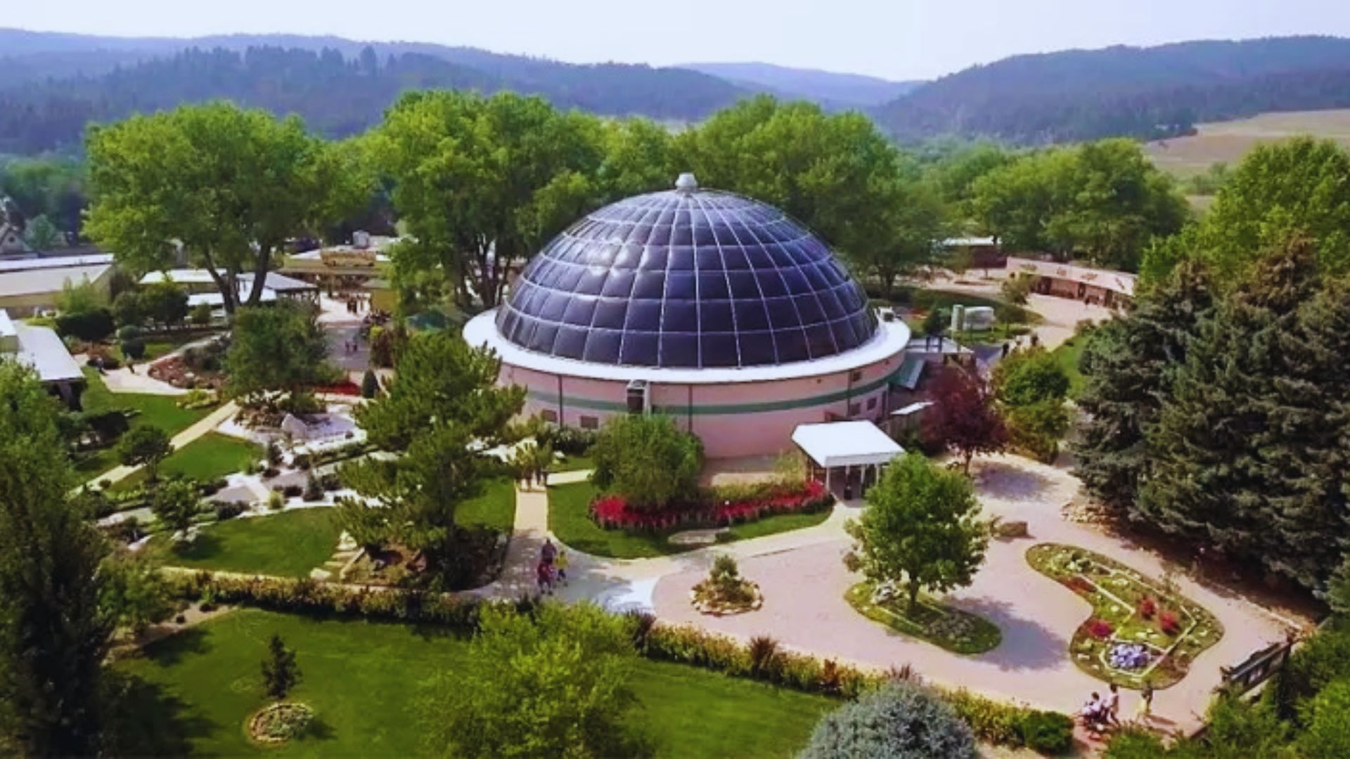A view of the botanical gardens in Colorado, showcasing the elegant dome surrounded by lush greenery and vibrant flowers.