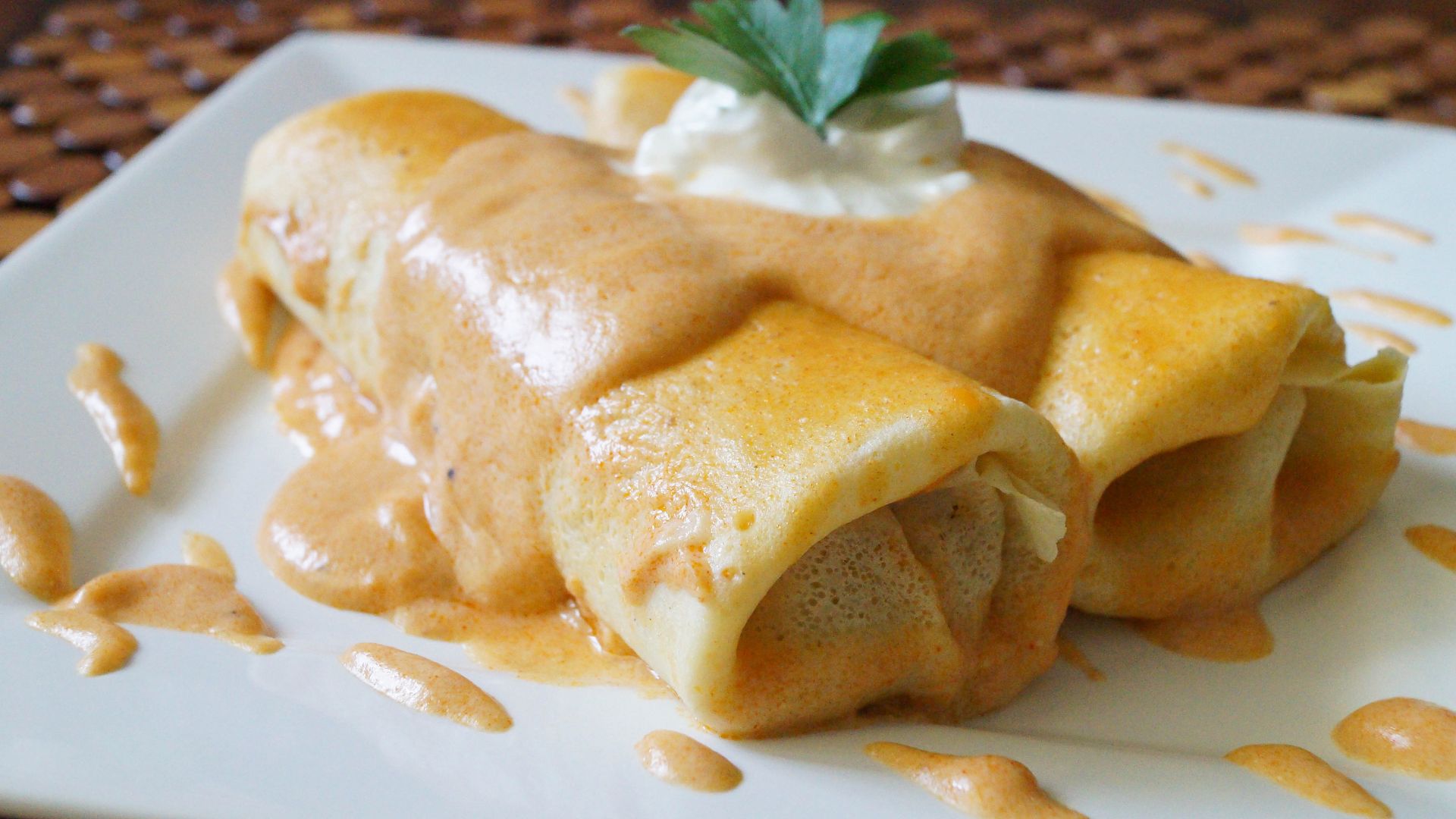 A plate holds two neatly arranged crepes, showcasing their golden-brown color and delicate texture.