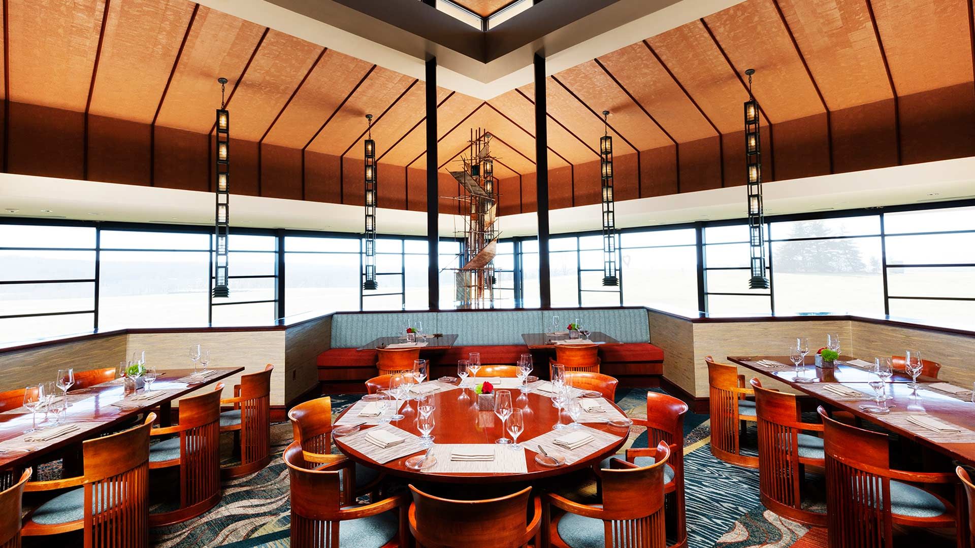 A spacious restaurant dining room featuring a large window that allows natural light to fill the space.