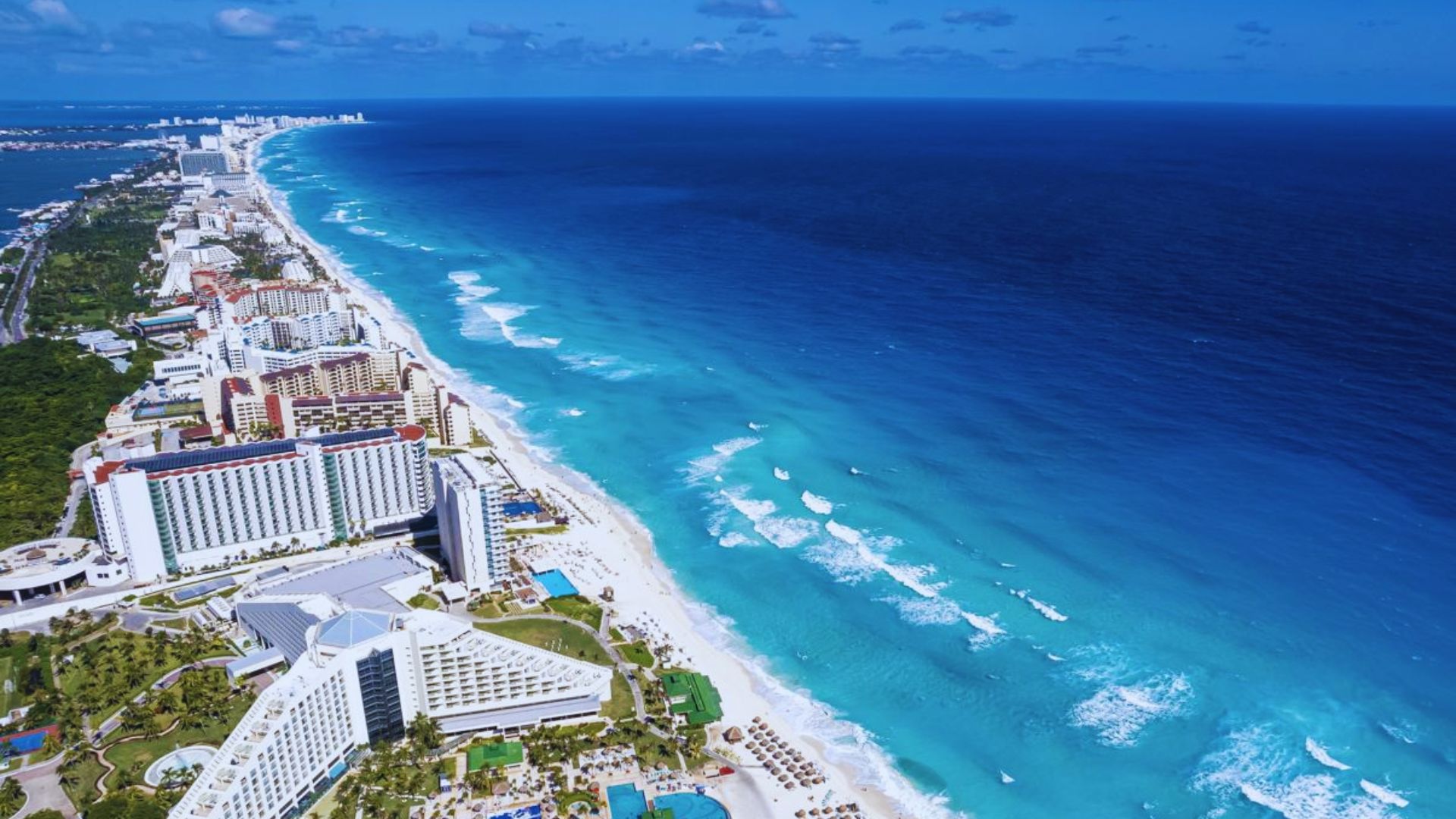 Scenic view of Cancun Beach in Mexico, featuring white sand, turquoise waters, and a clear blue sky.