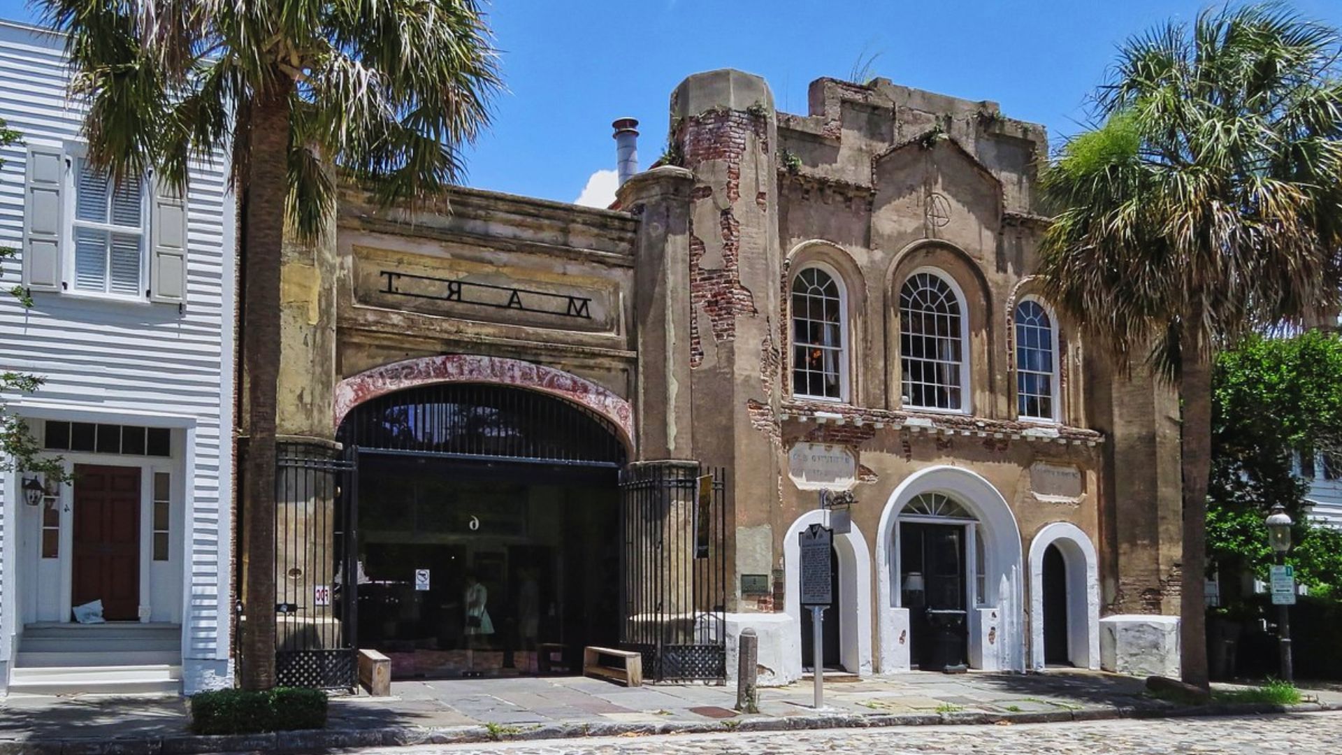 An old building stands at the corner of a street, showcasing its historic architecture and weathered facade.