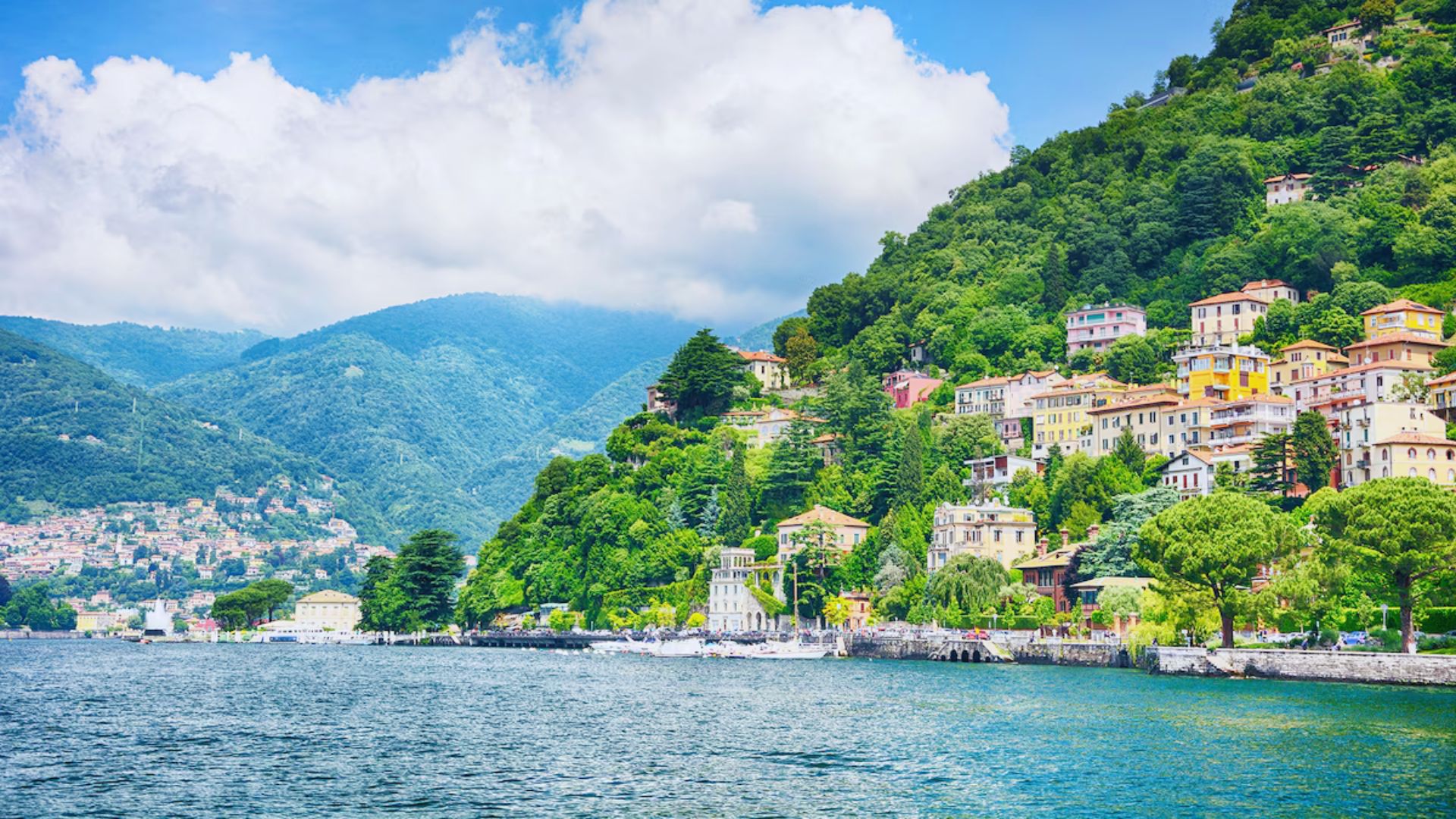 Scenic view of Como, Italy, showcasing the town's charming architecture and surrounding mountains by the lake.