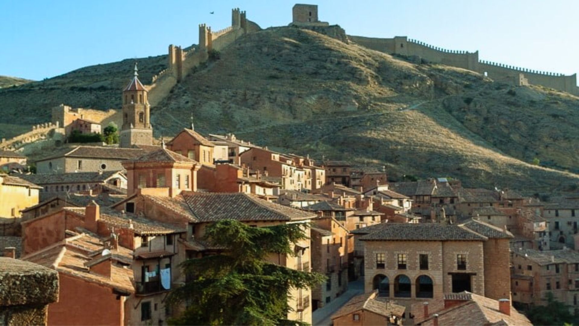 A panoramic view of Tarragona's old town, showcasing historic buildings and narrow streets under a clear blue sky.