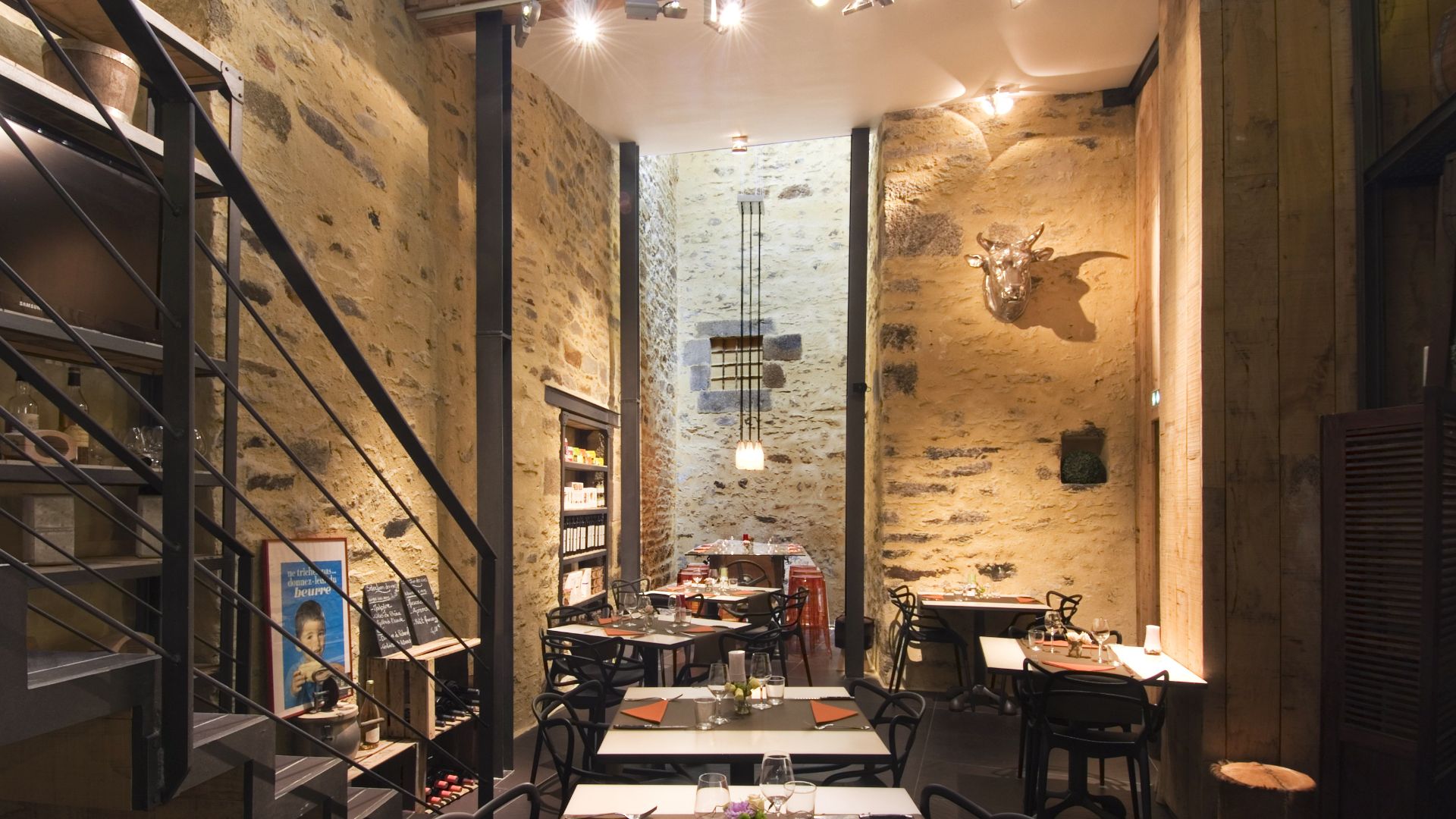 A narrow hallway restaurant featuring tables and chairs arranged along the sides for dining.