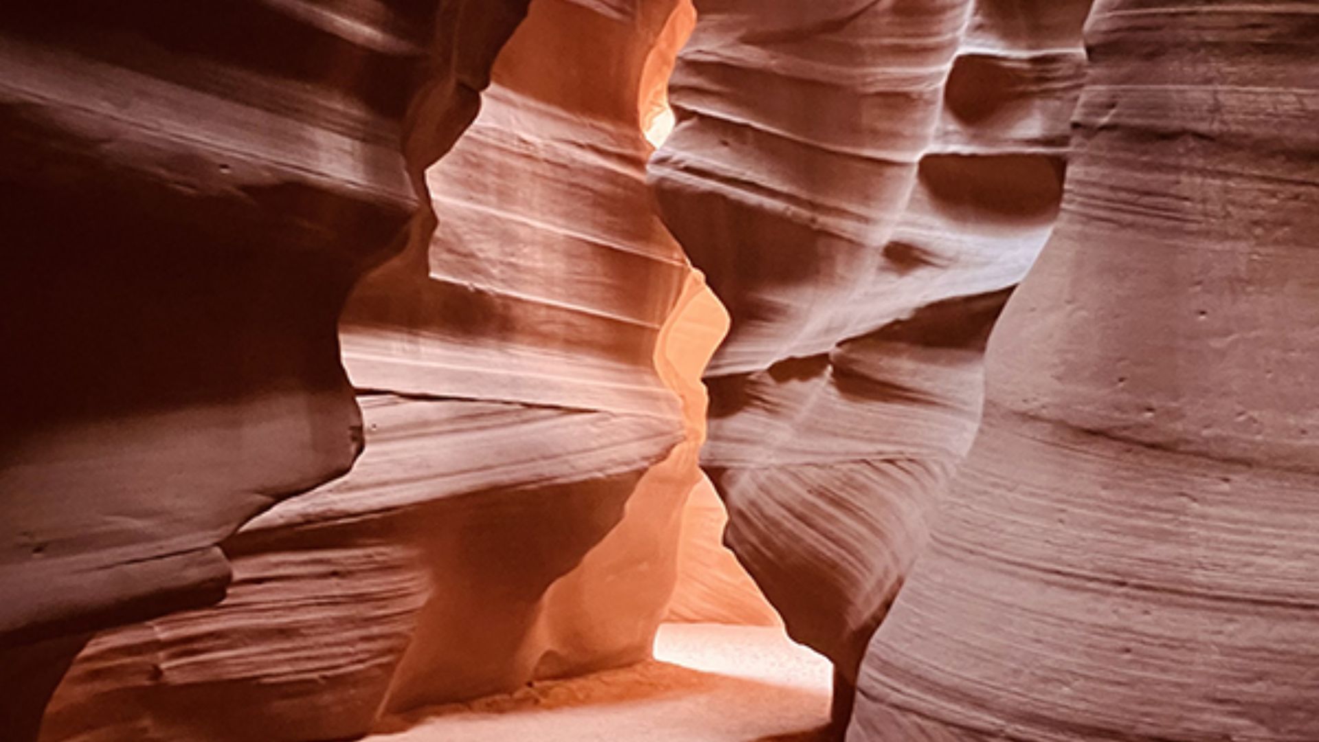 Antelope Canyon in Arizona, USA, showcasing stunning red rock formations and narrow passageways illuminated by sunlight.