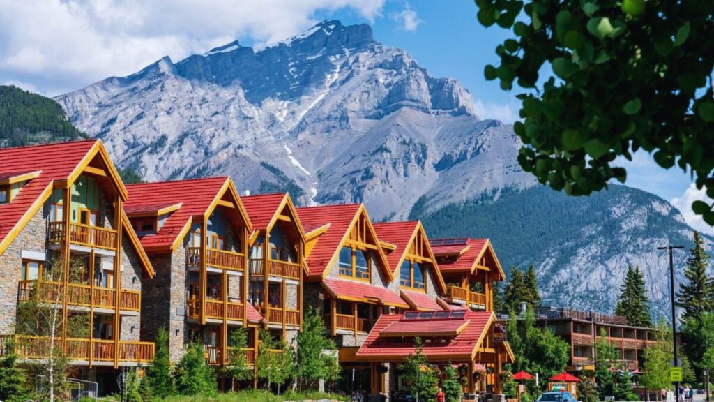 Where to Stay in Banff Best Areas & Hotels The lodge at Banff National Park, surrounded by majestic mountains and lush greenery, showcasing its rustic architecture.