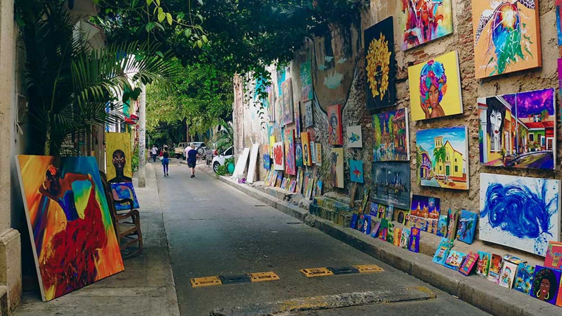 A vibrant street adorned with colorful murals and paintings on the walls, showcasing artistic expressions.