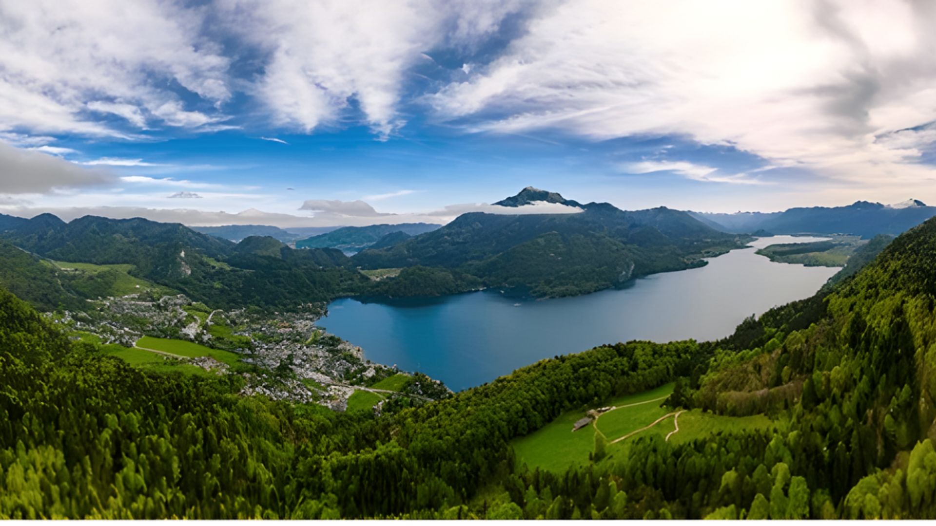 Panoramic view of a serene lake surrounded by majestic mountains under a clear blue sky.