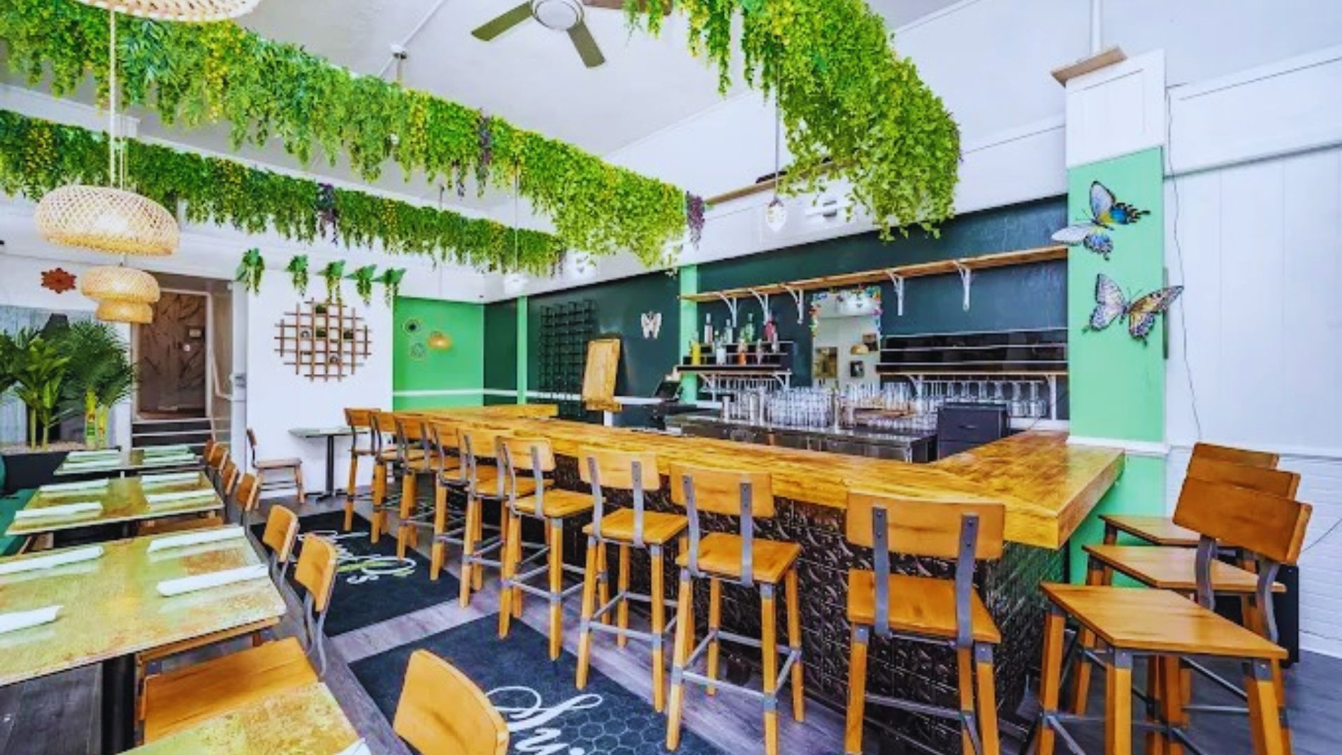 A cozy restaurant featuring green walls and wooden tables, creating a warm and inviting atmosphere for diners.