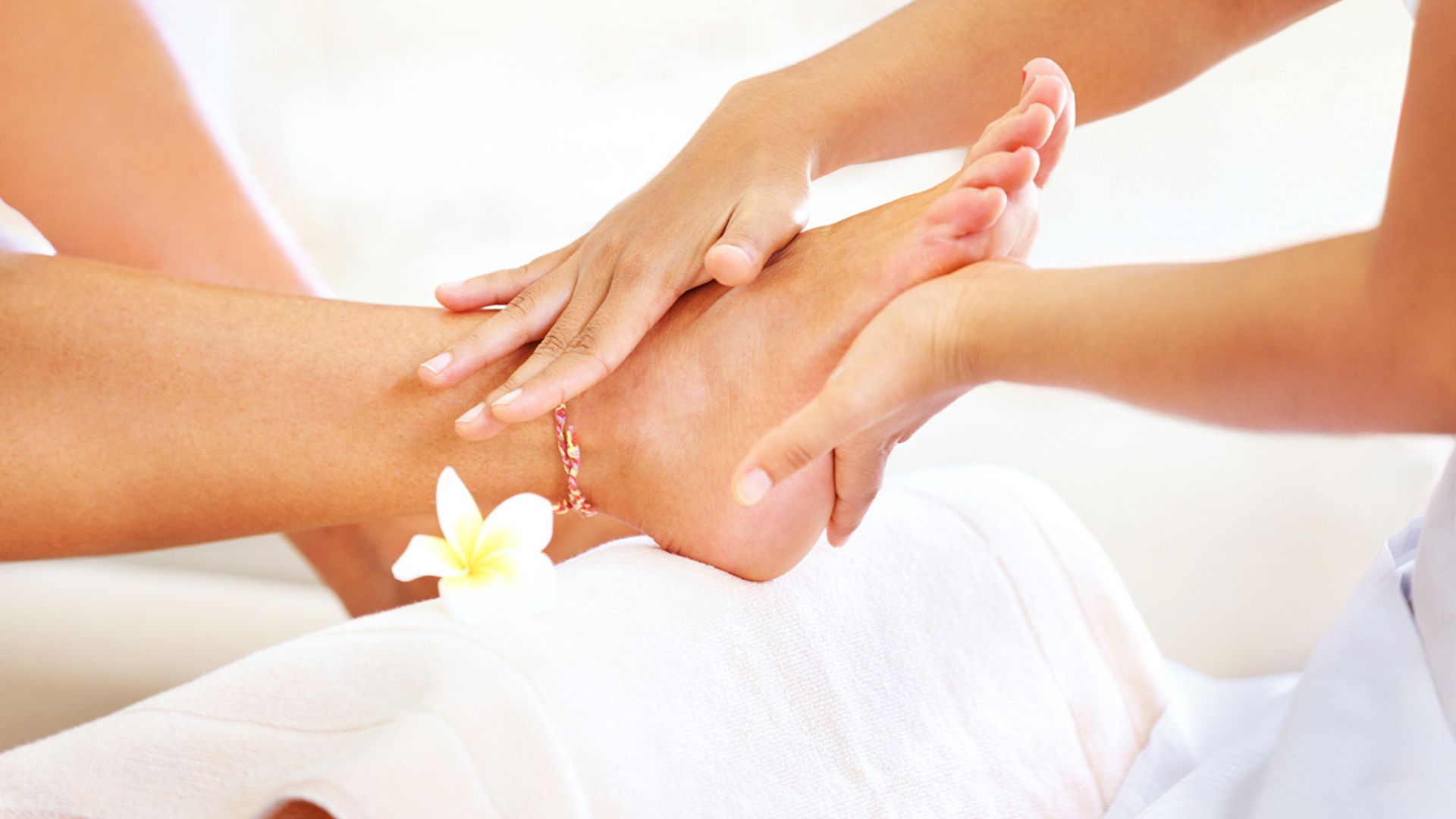 A woman experiencing a rejuvenating foot massage at a peaceful spa setting.