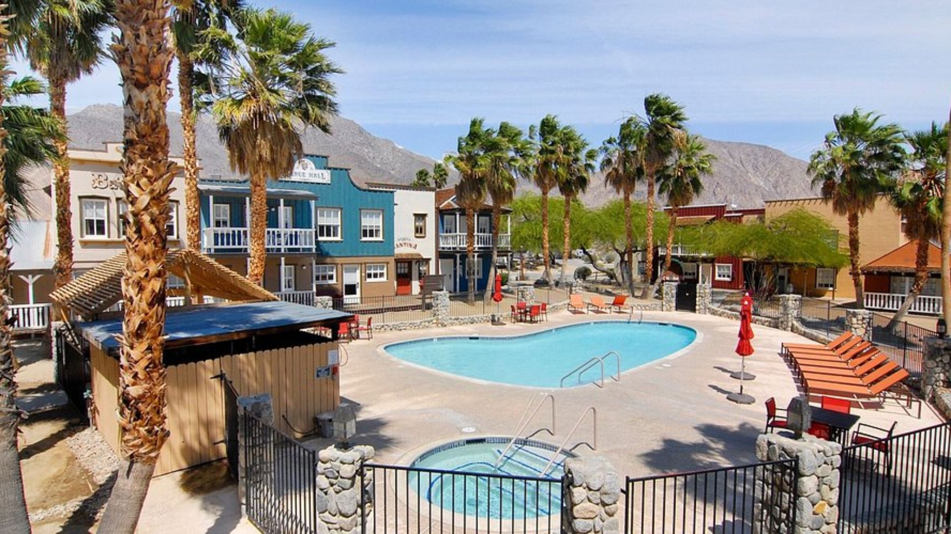 A serene pool surrounded by palm trees at the Palm Springs resort, inviting guests to relax and enjoy the sunny atmosphere.