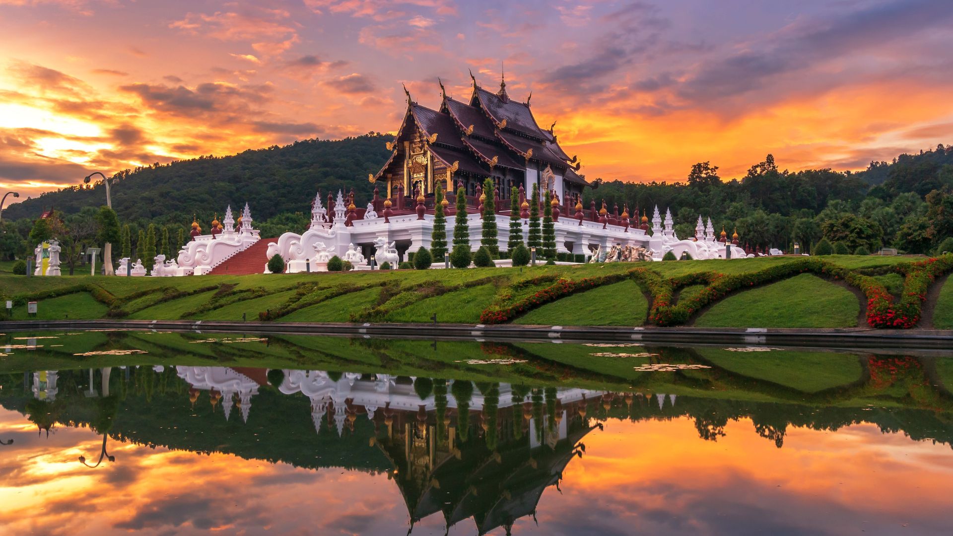 Stunning view of Wat Phra Kaew temple in Thailand, showcasing intricate architecture and vibrant colors against a clear sky.