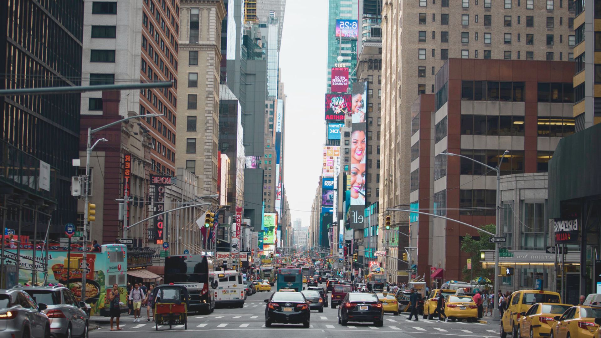 A bustling city street filled with cars and pedestrians navigating through the busy urban environment.