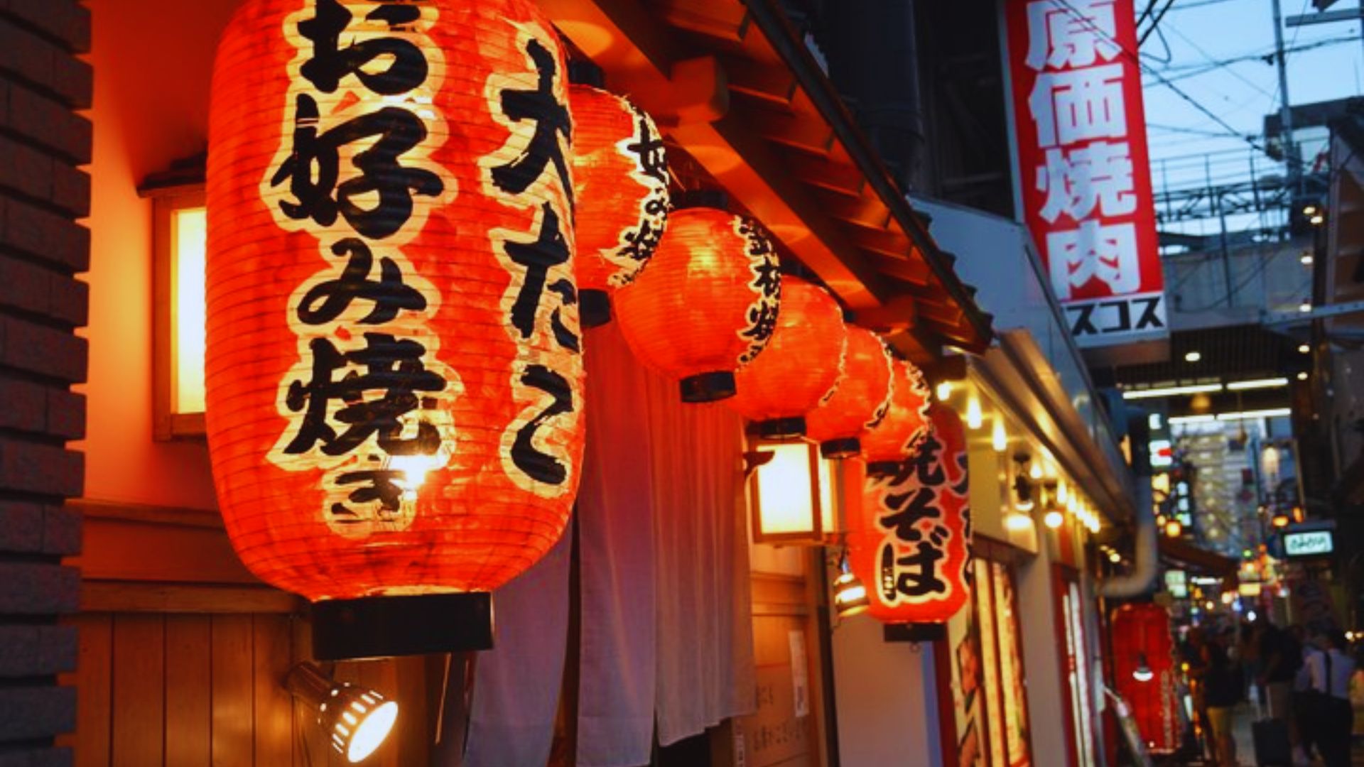 A vibrant street adorned with numerous Asian lanterns hanging from the buildings, creating a festive atmosphere.