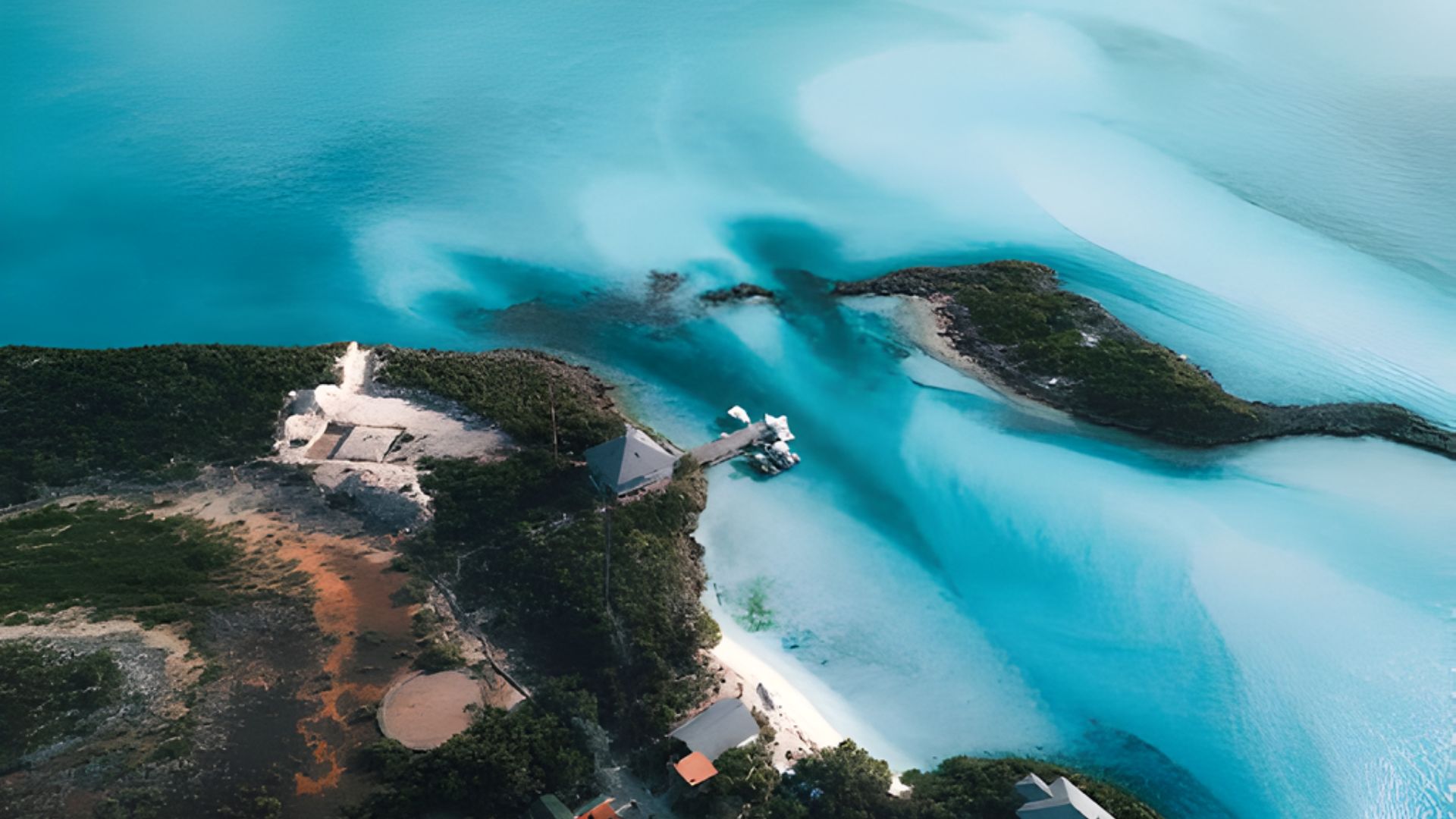 Aerial view of a coastal landscape with vibrant turquoise waters and lush greenery. Tiny islands and sandy beaches create a serene, tropical atmosphere.