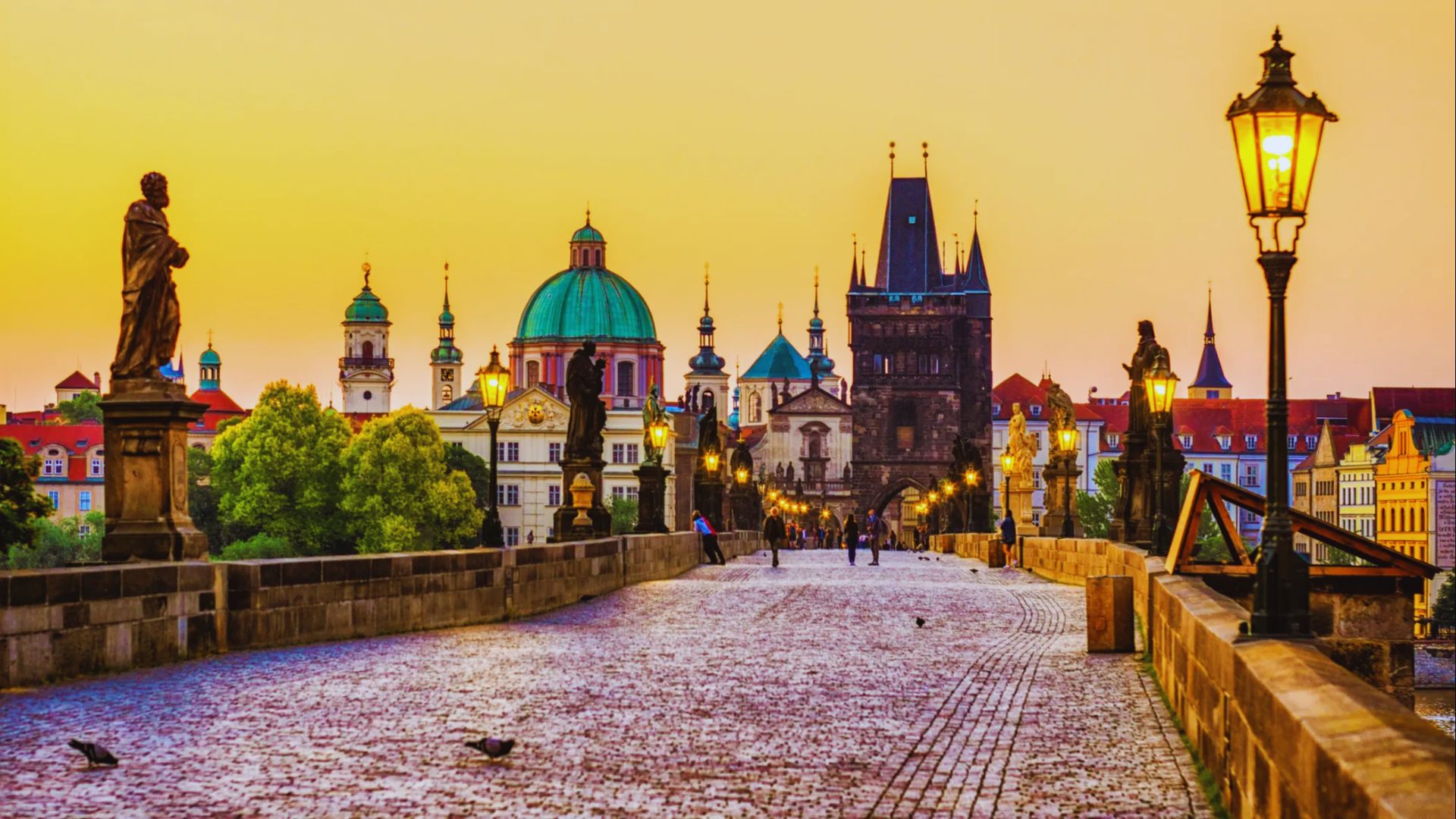The historic Charles Bridge in Prague, Czech Republic, spans the Vltava River, adorned with statues and bustling with visitors.