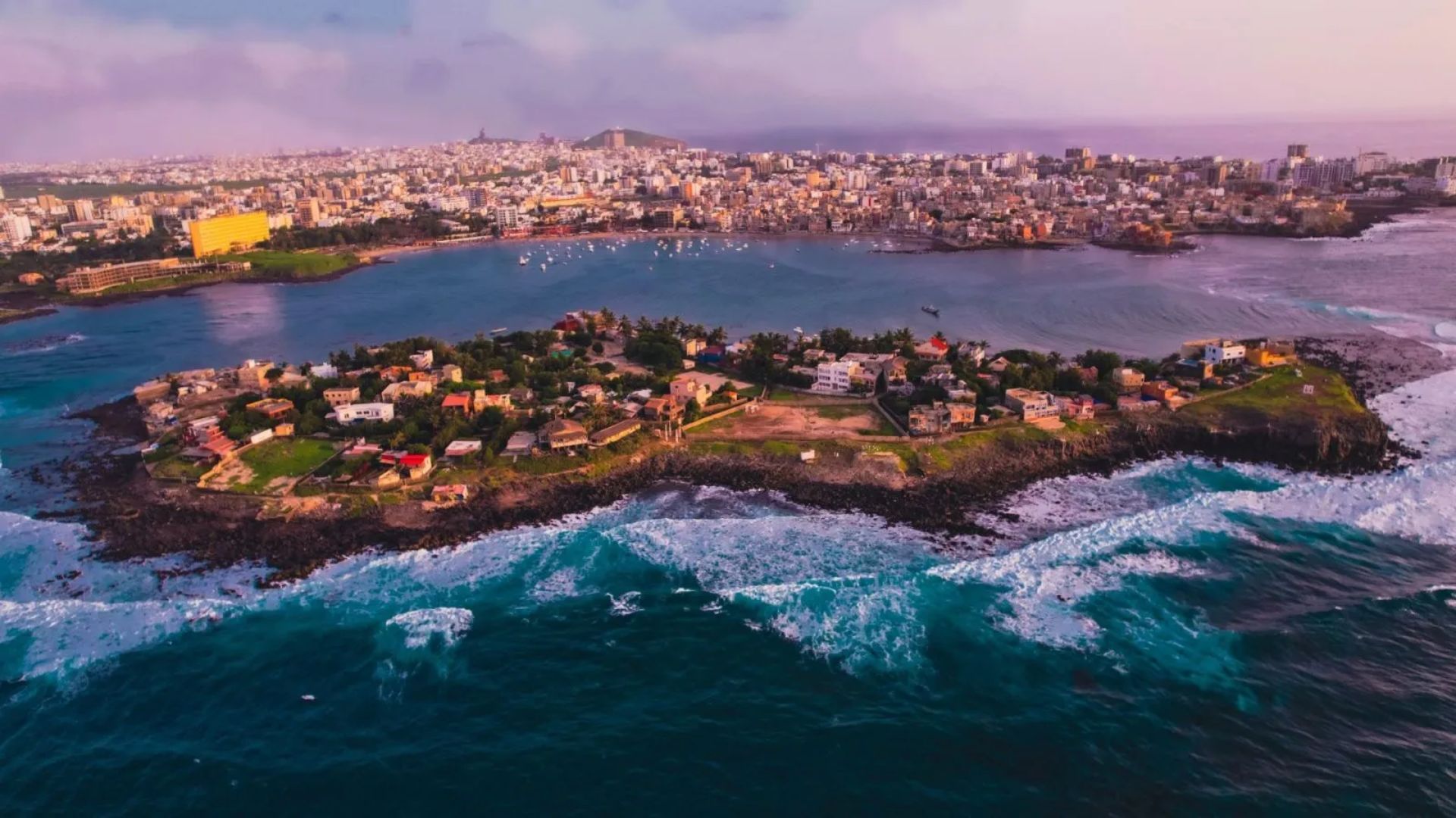 . Aerial view of a small island featuring houses surrounded by blue water, showcasing a serene coastal landscape.