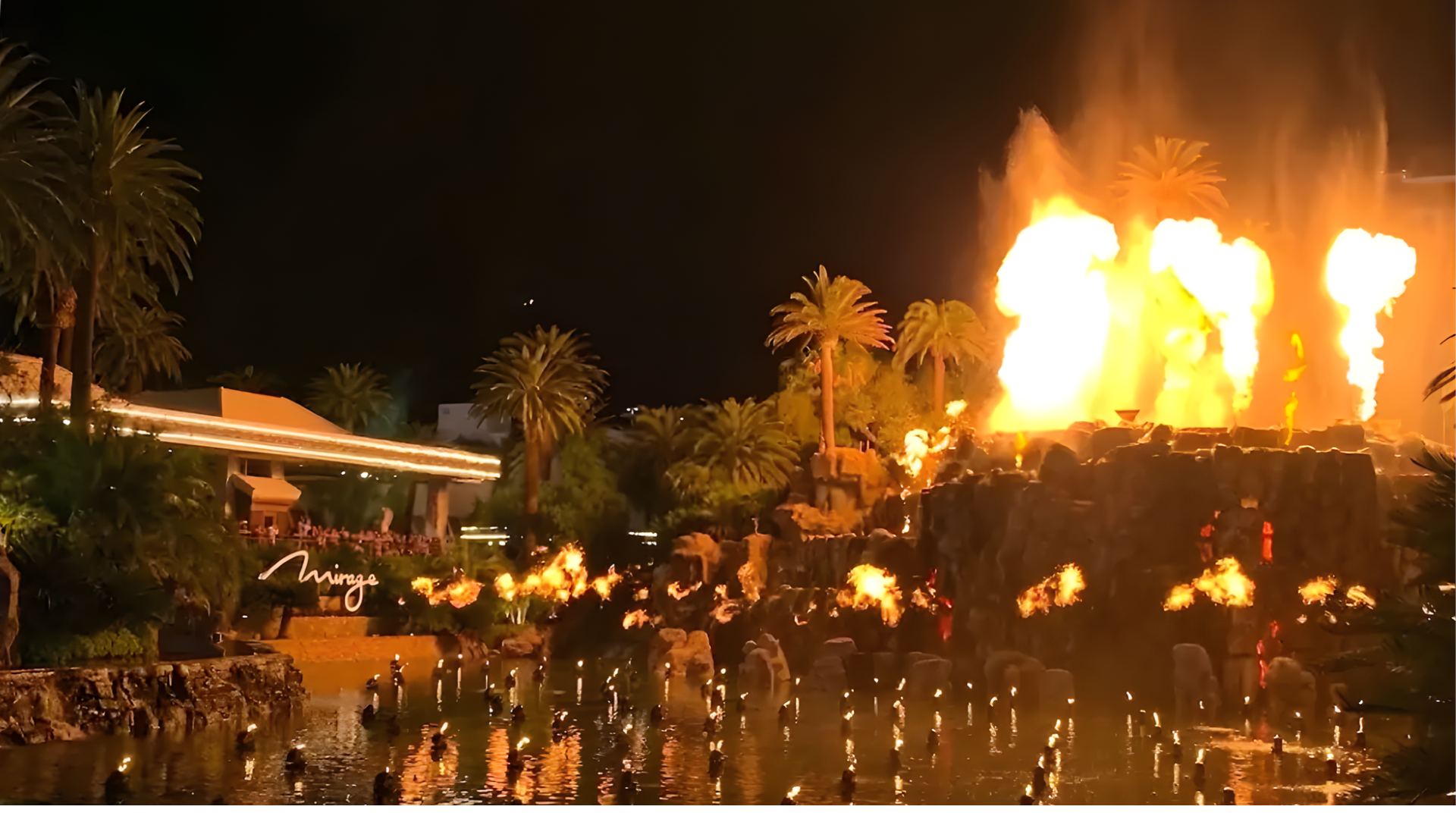 A fountain with flames shooting up, surrounded by people enjoying the water below.