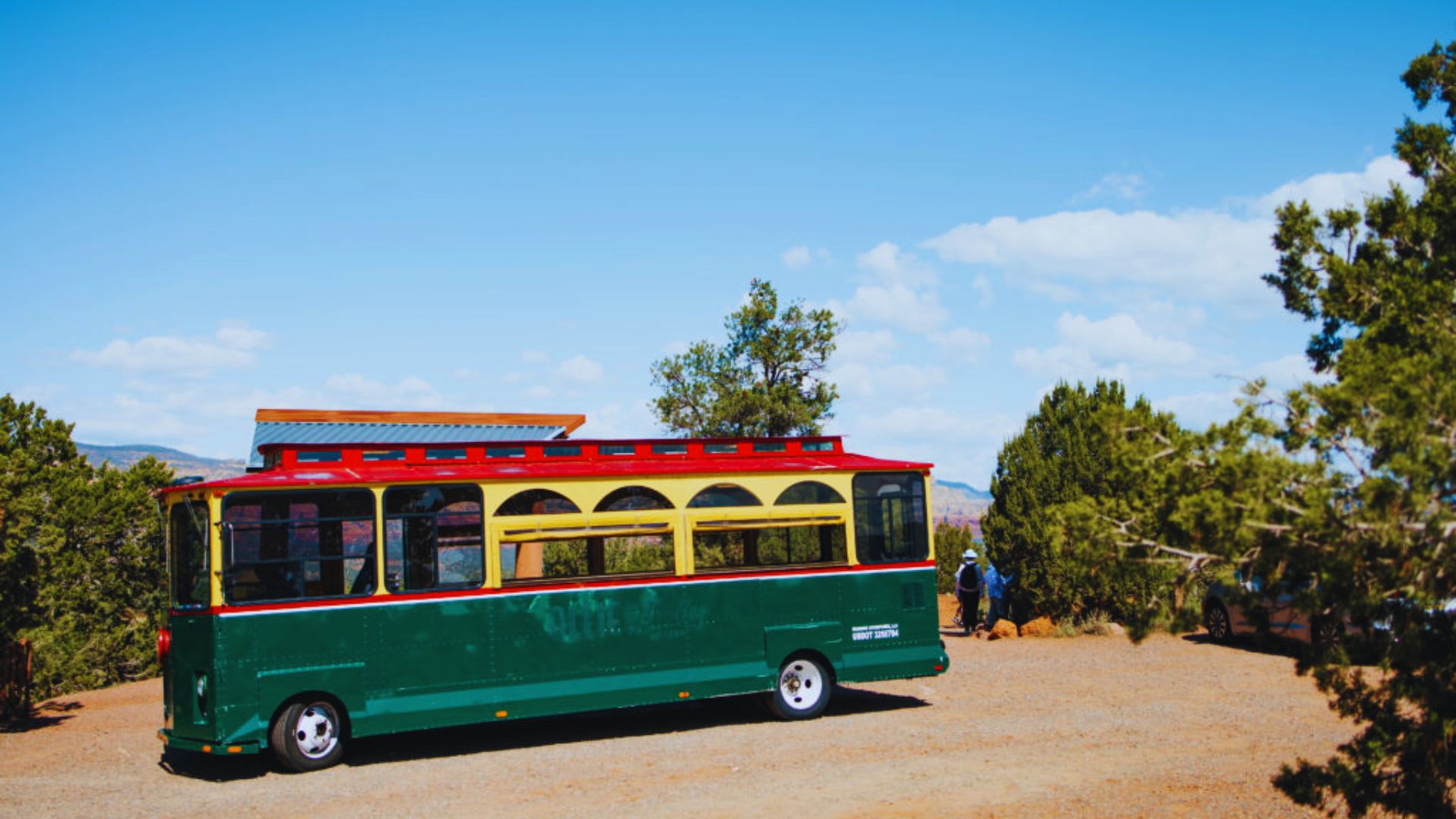 A green and red bus parked on the street, showcasing its vibrant colors against the urban backdrop.
