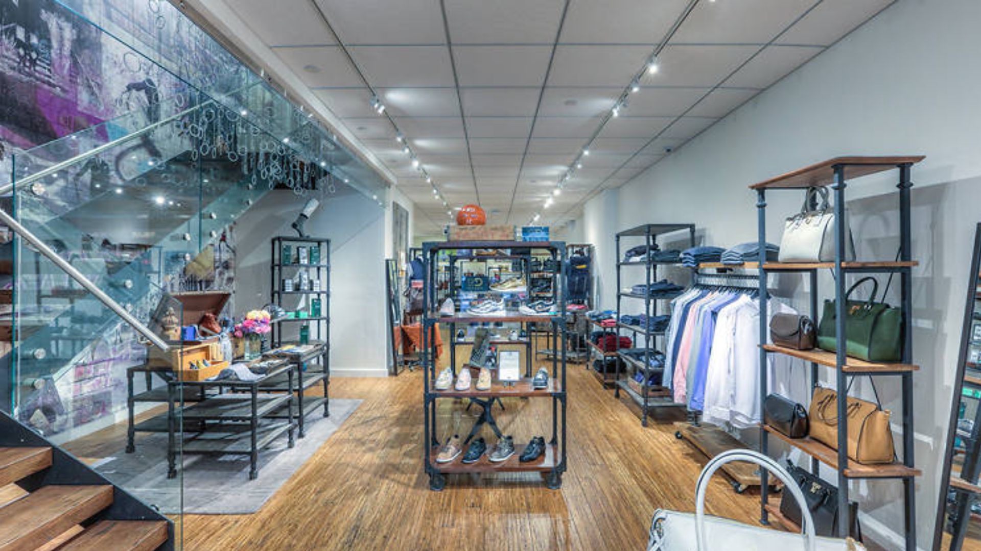 Interior of a store with expansive glass walls and warm wooden flooring, enhancing the overall aesthetic appeal.