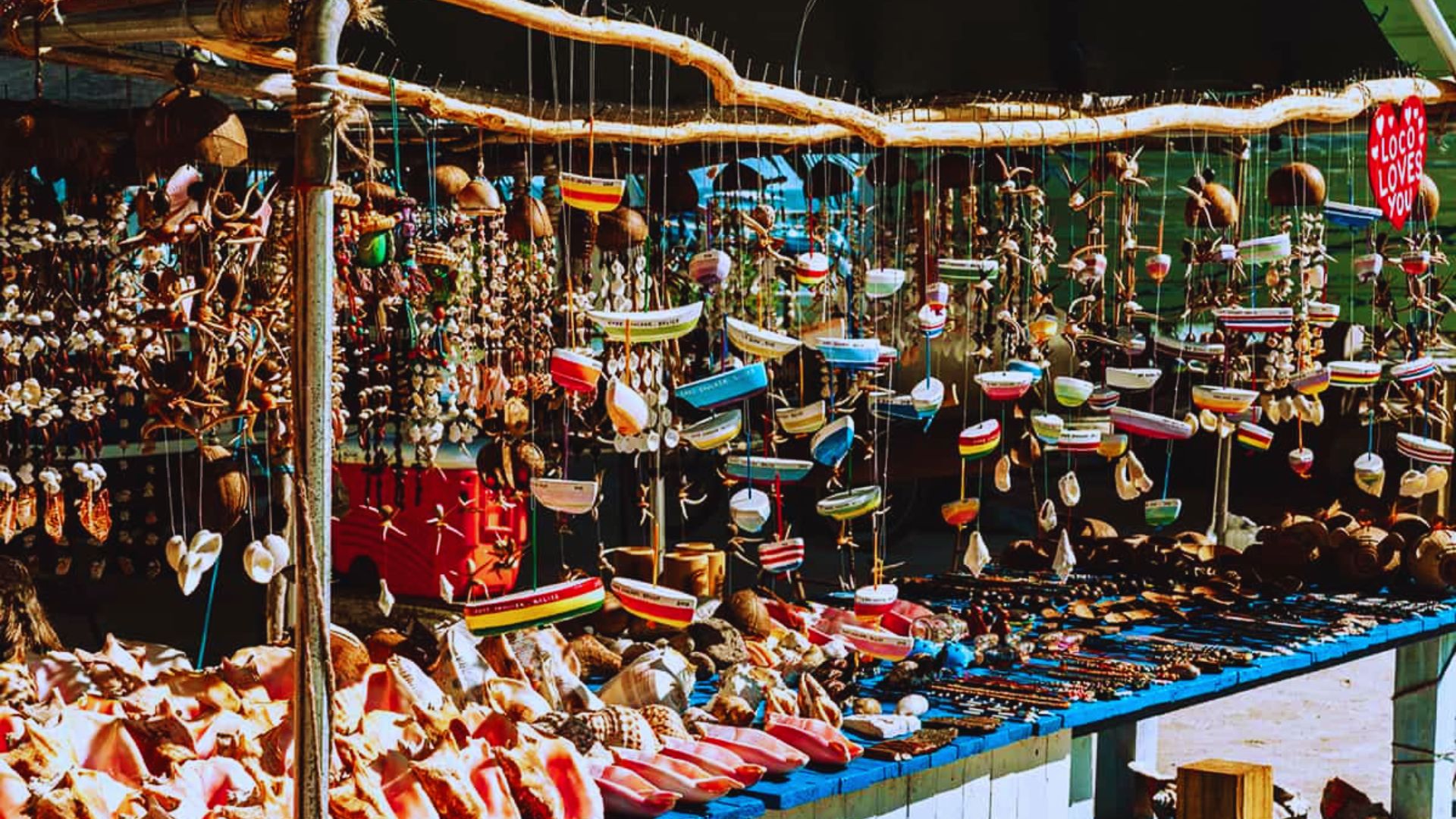 A bustling market filled with a variety of items, including fruits, vegetables, crafts, and clothing.
