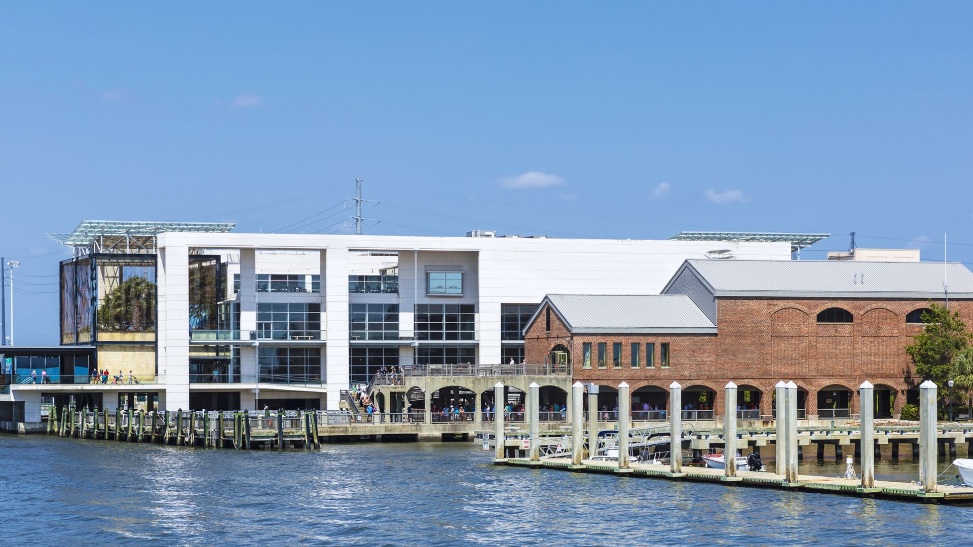 A serene body of water reflecting the sky, surrounded by lush greenery and distant hills.