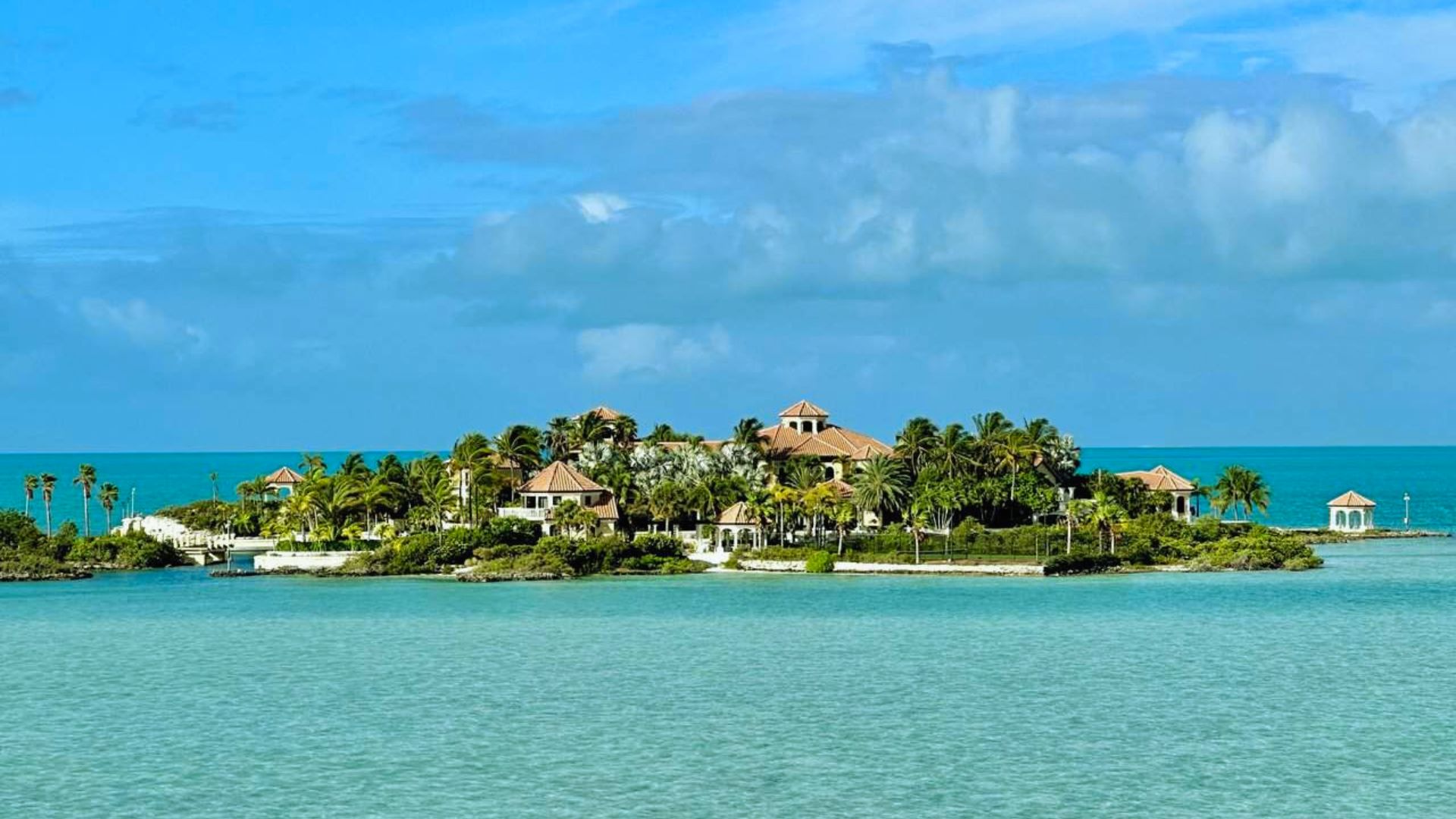 A solitary house sits on an island surrounded by vast ocean waters.