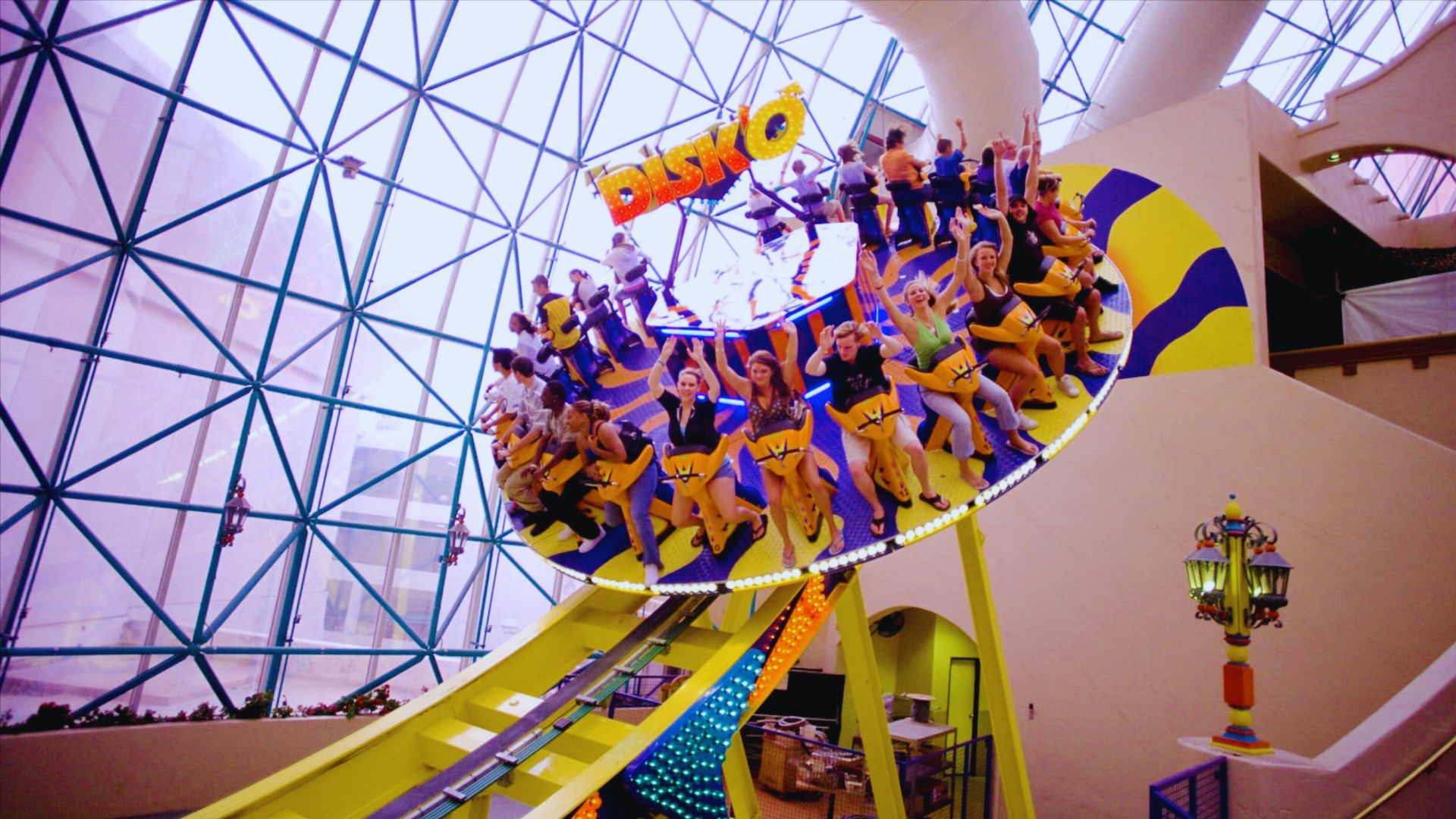 A group of excited people enjoying a thrilling ride on a roller coaster, with their hands raised in the air.