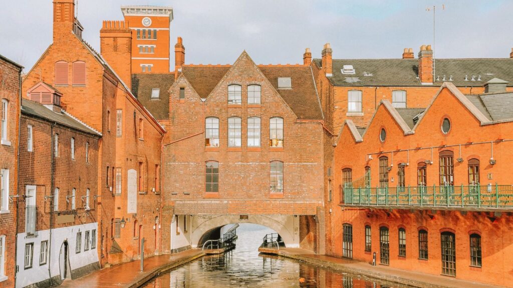 A city canal with a bridge crossing over it, surrounded by various buildings lining the waterway.