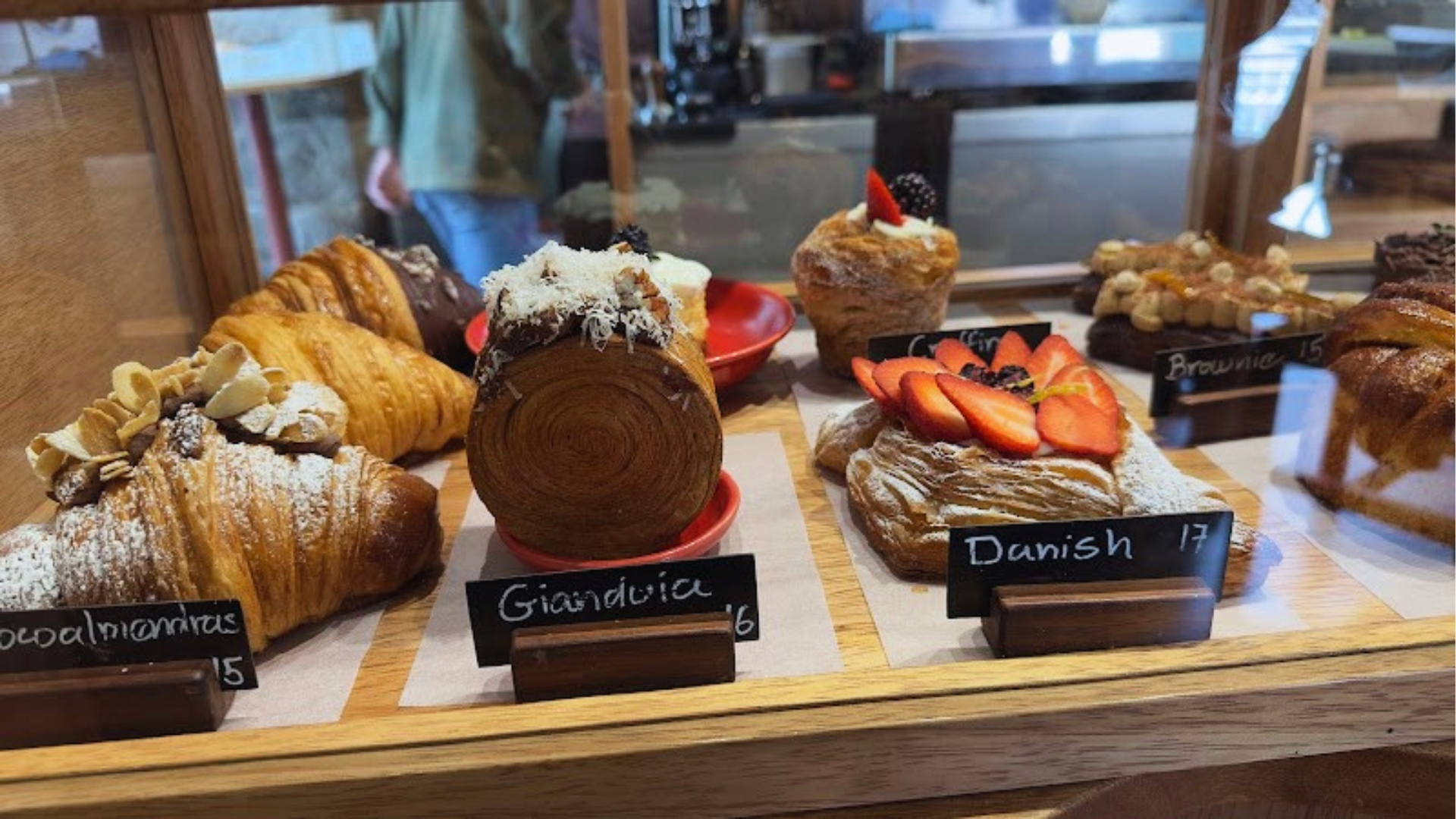 A display case filled with an assortment of colorful pastries, showcasing various shapes and textures.