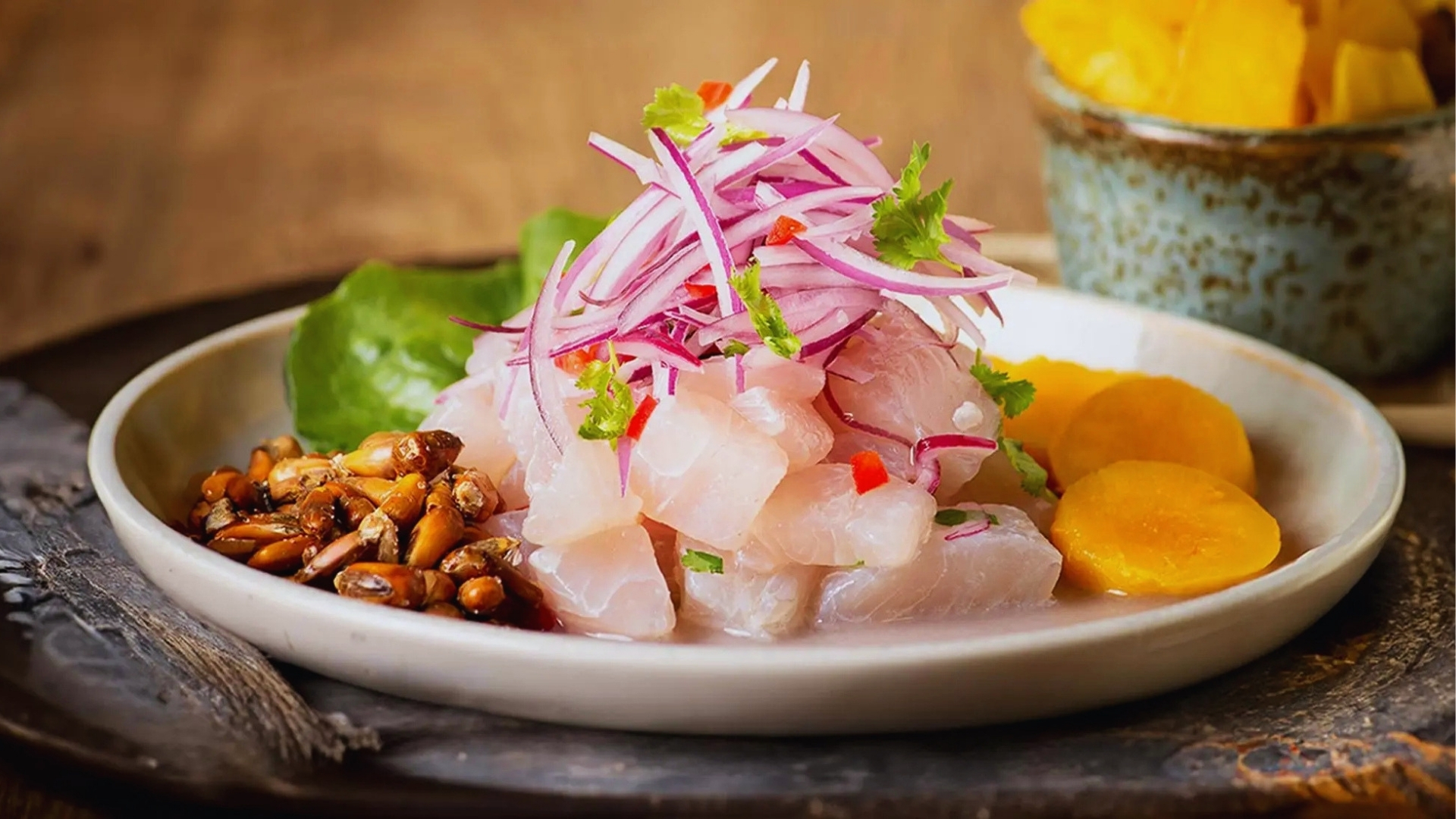 A plate featuring a piece of fish accompanied by a variety of colorful vegetables.