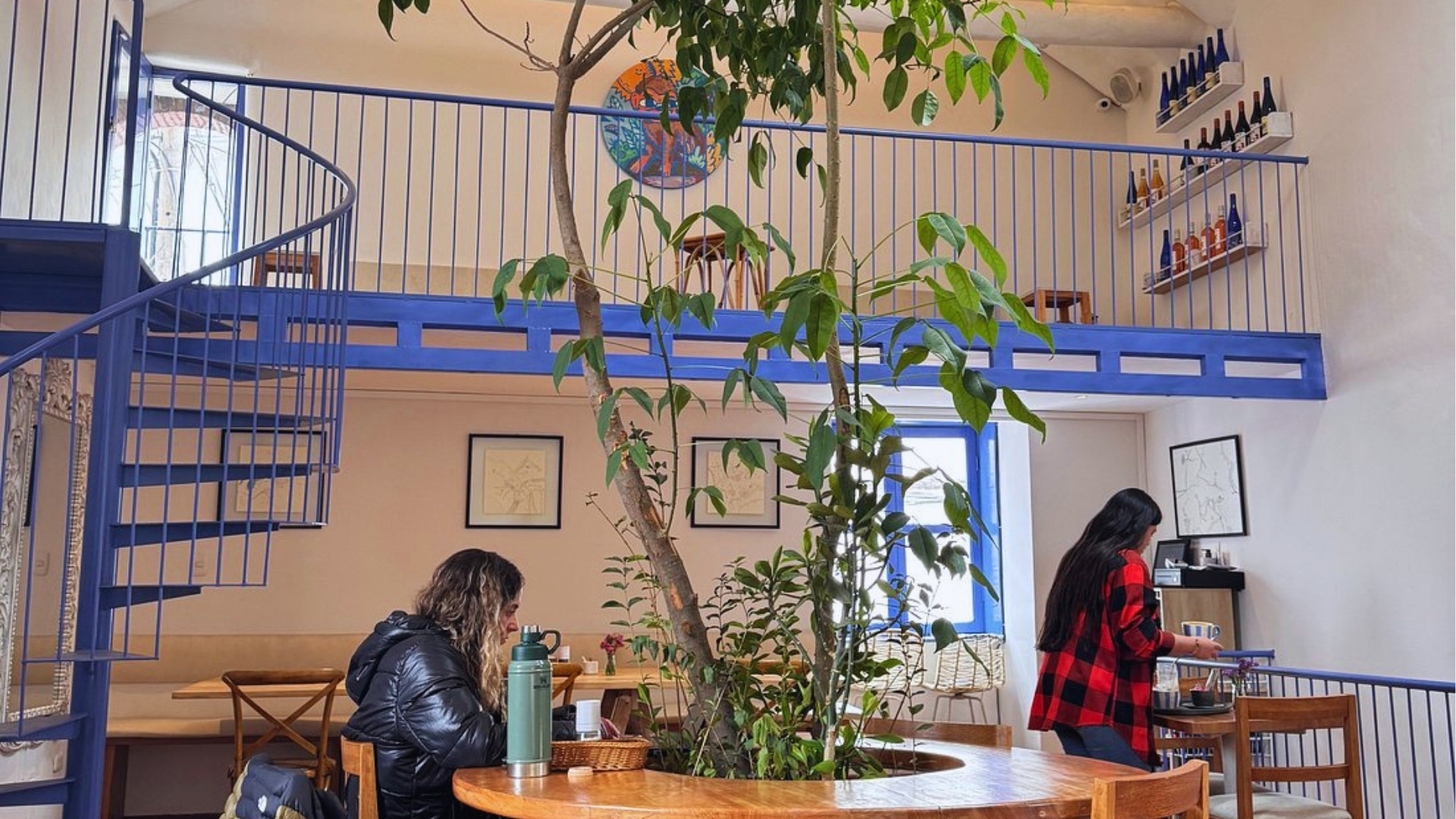 Two people seated at a table in a restaurant, engaged in conversation over a meal.