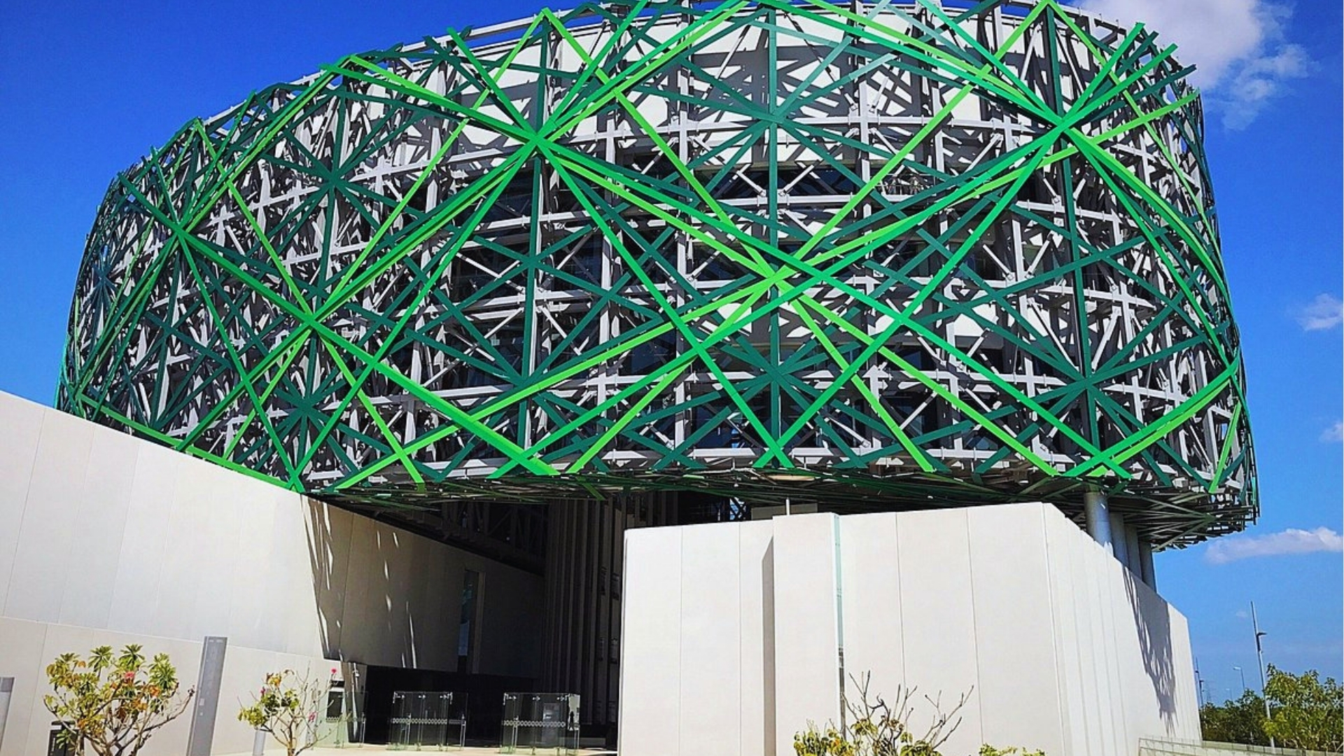 A building featuring green and white metal structures, showcasing a modern architectural design.