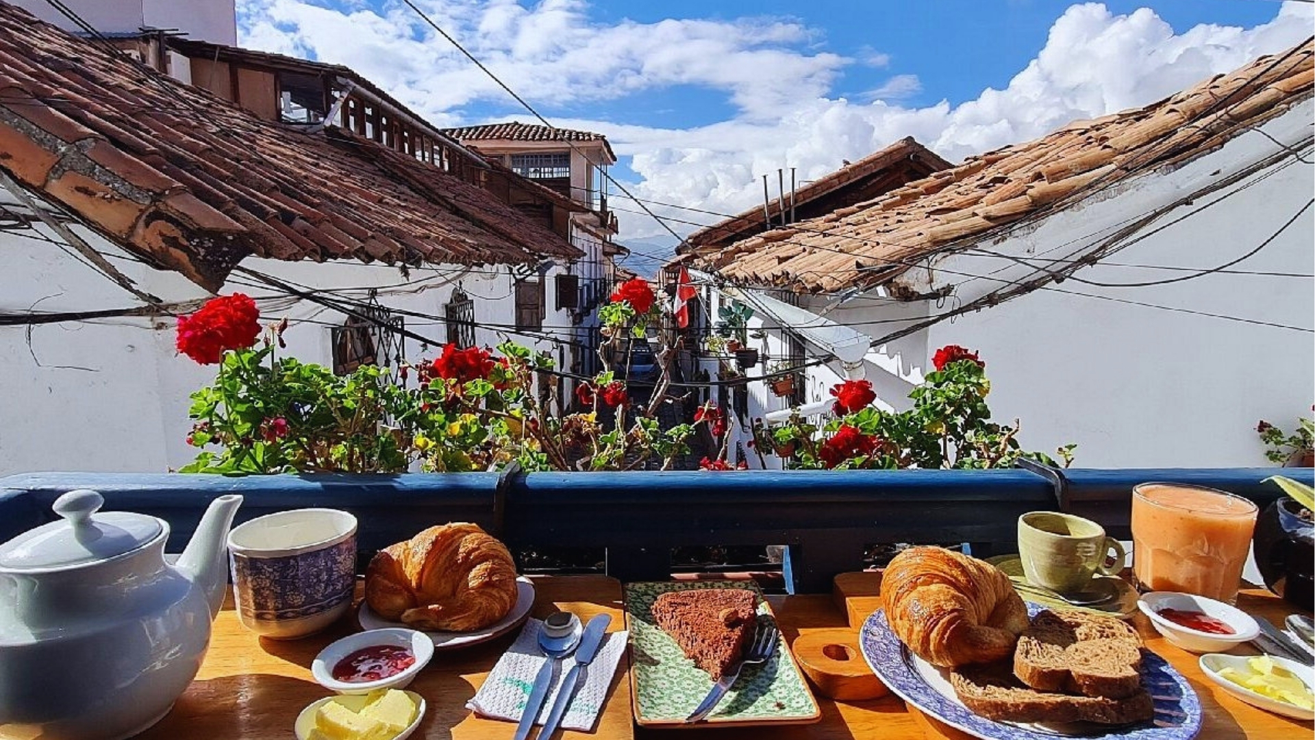 Breakfast spread on a terrace of a colonial house in Cusco, Peru, featuring traditional dishes and scenic views.