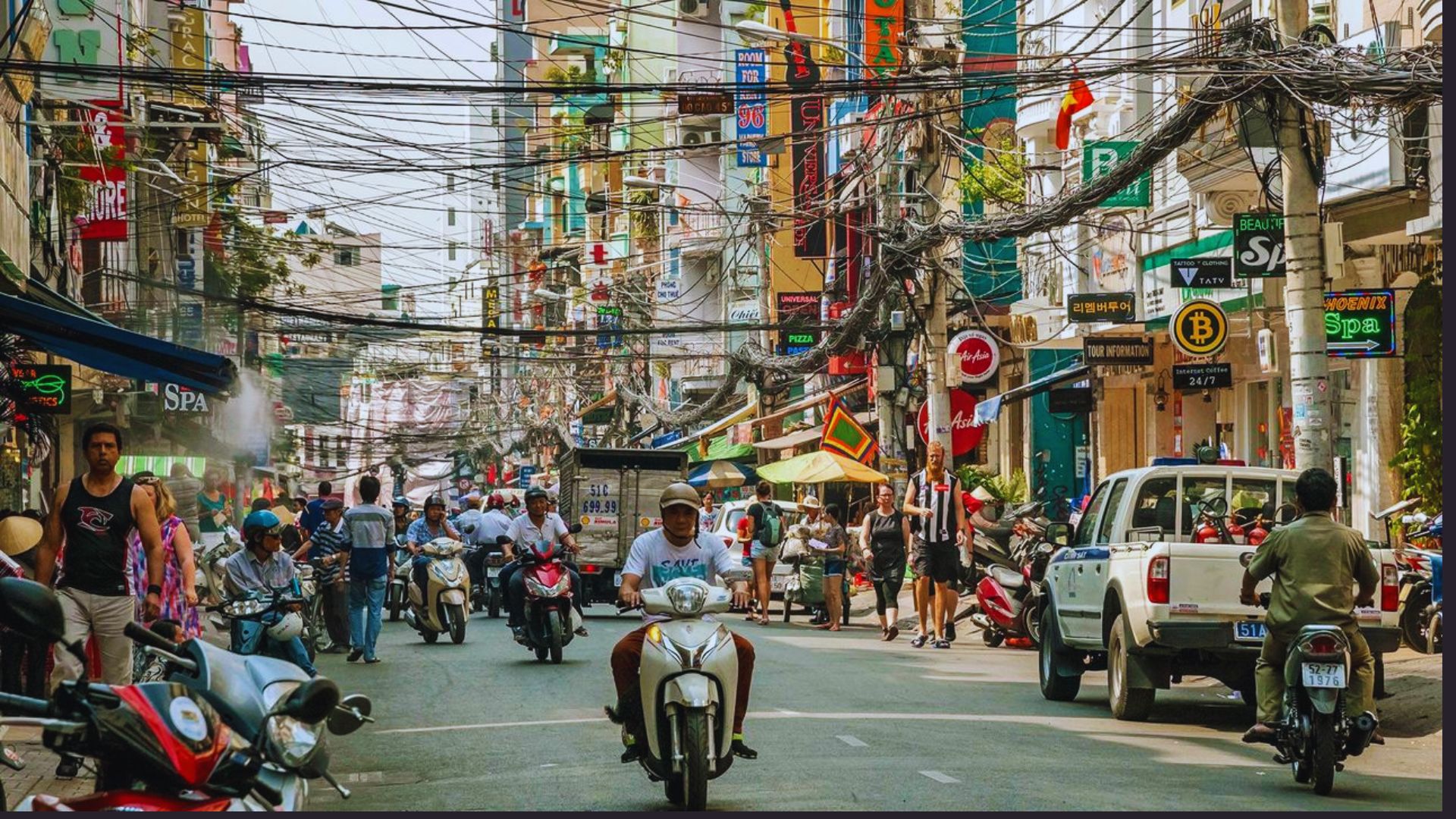 A bustling street filled with numerous people riding motorcycles, showcasing urban life and movement.