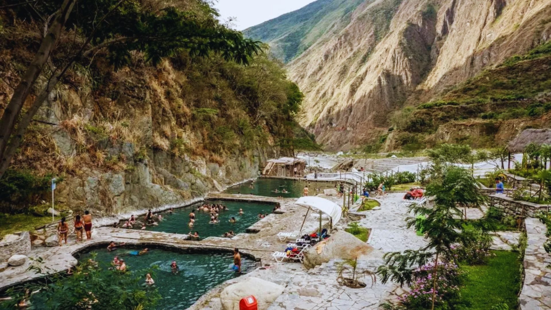 Scenic view of the hot springs along the Inca Trail, surrounded by lush greenery and rugged mountains.