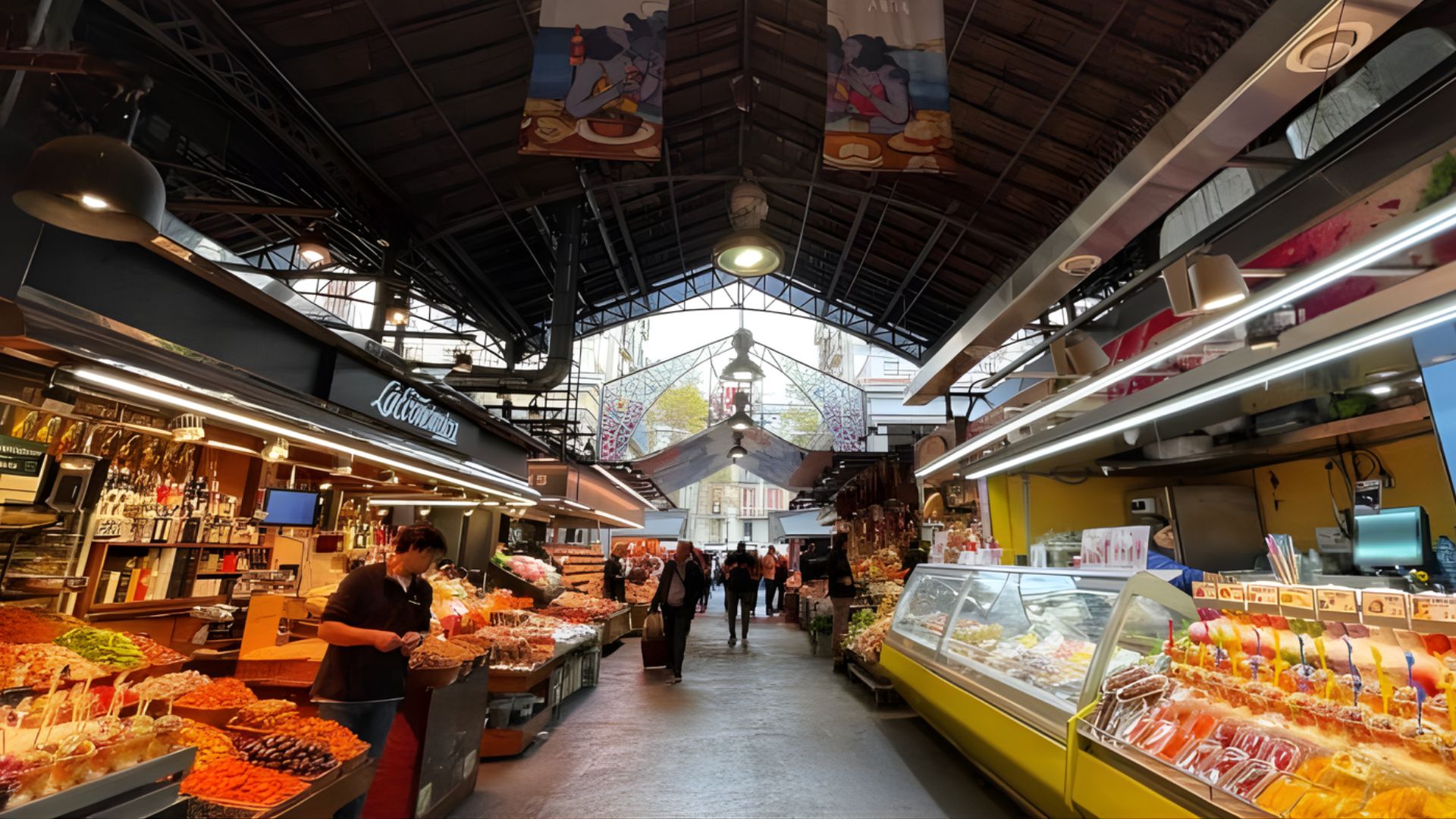 Bustling indoor market with colorful produce, meats, and cheeses on display. Shoppers browse under a high, arched ceiling with hanging banners.