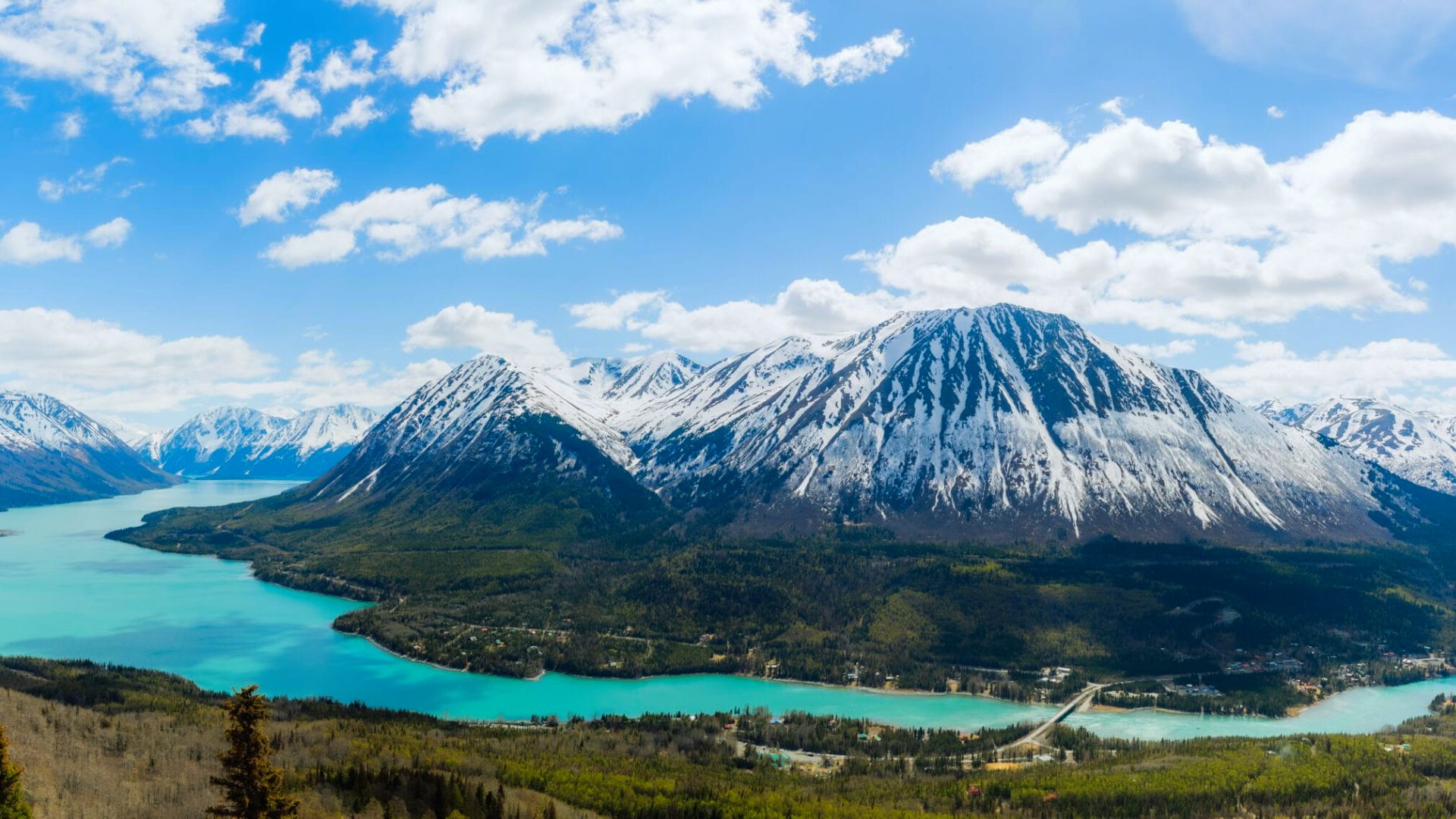 Scenic view of mountains with a serene lake in the background under a clear blue sky.